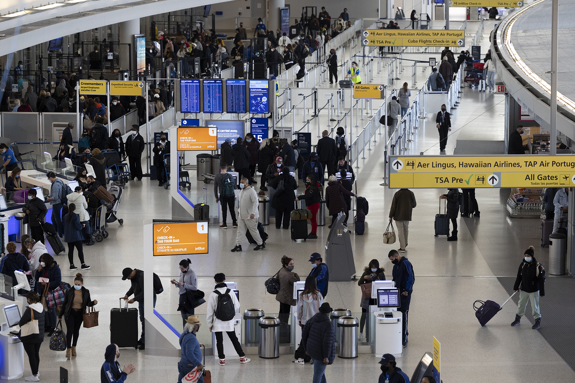 Travellers walk through Terminal 4 at John F. Kennedy International Airport (JFK) in New York, U.S., on Wednesday, November 24, 2021. 