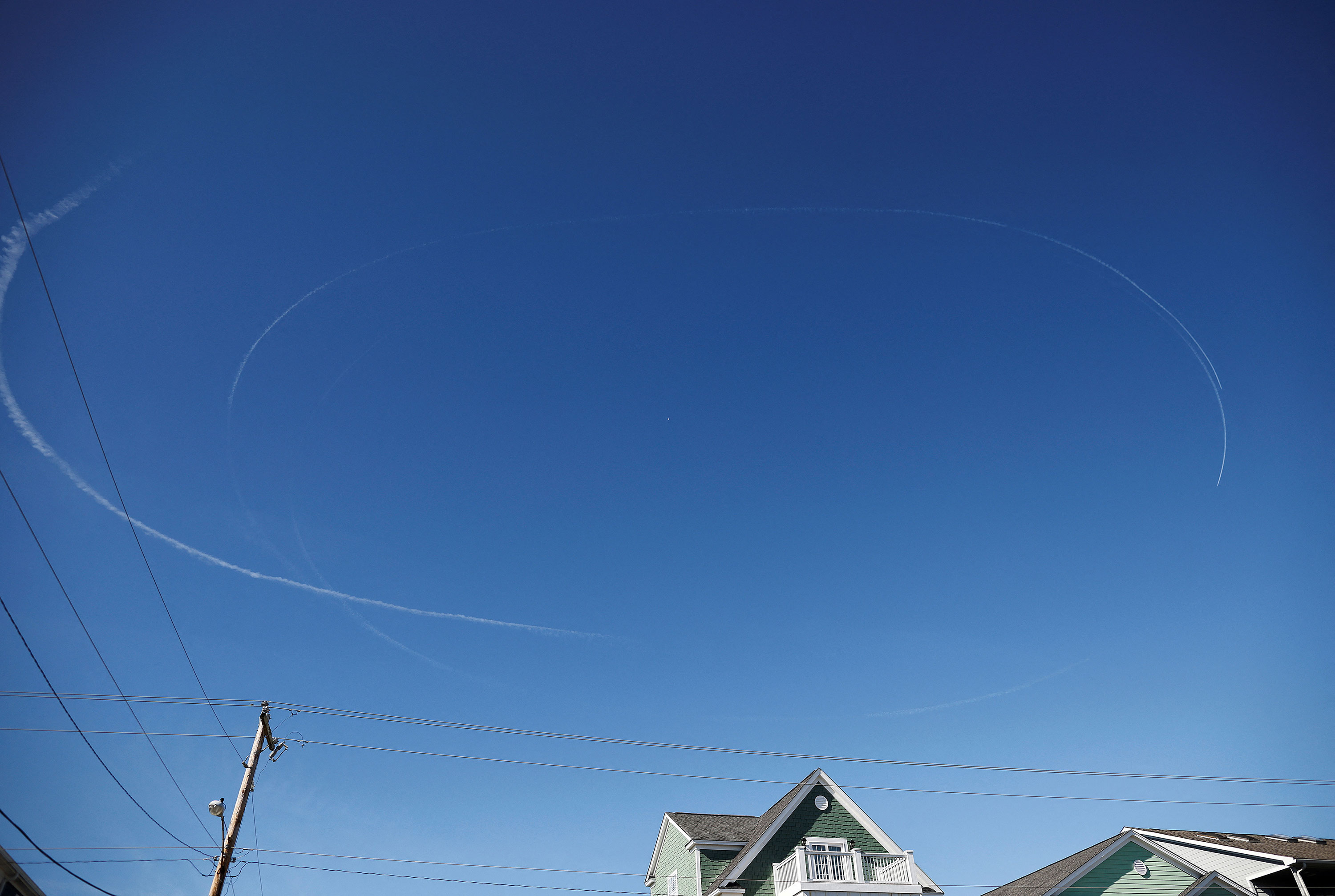 Contrails from jets circle the suspected Chinese spy balloon as it floats off the coast in Surfside Beach, South Carolina, on Saturday, February 4. 