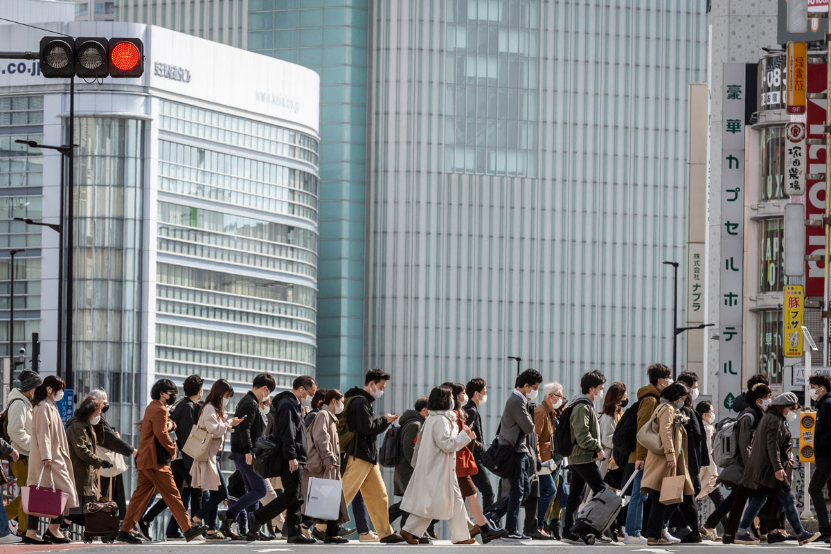 Commuters wearing face masks cross a street in Tokyo, Japan on March 22.