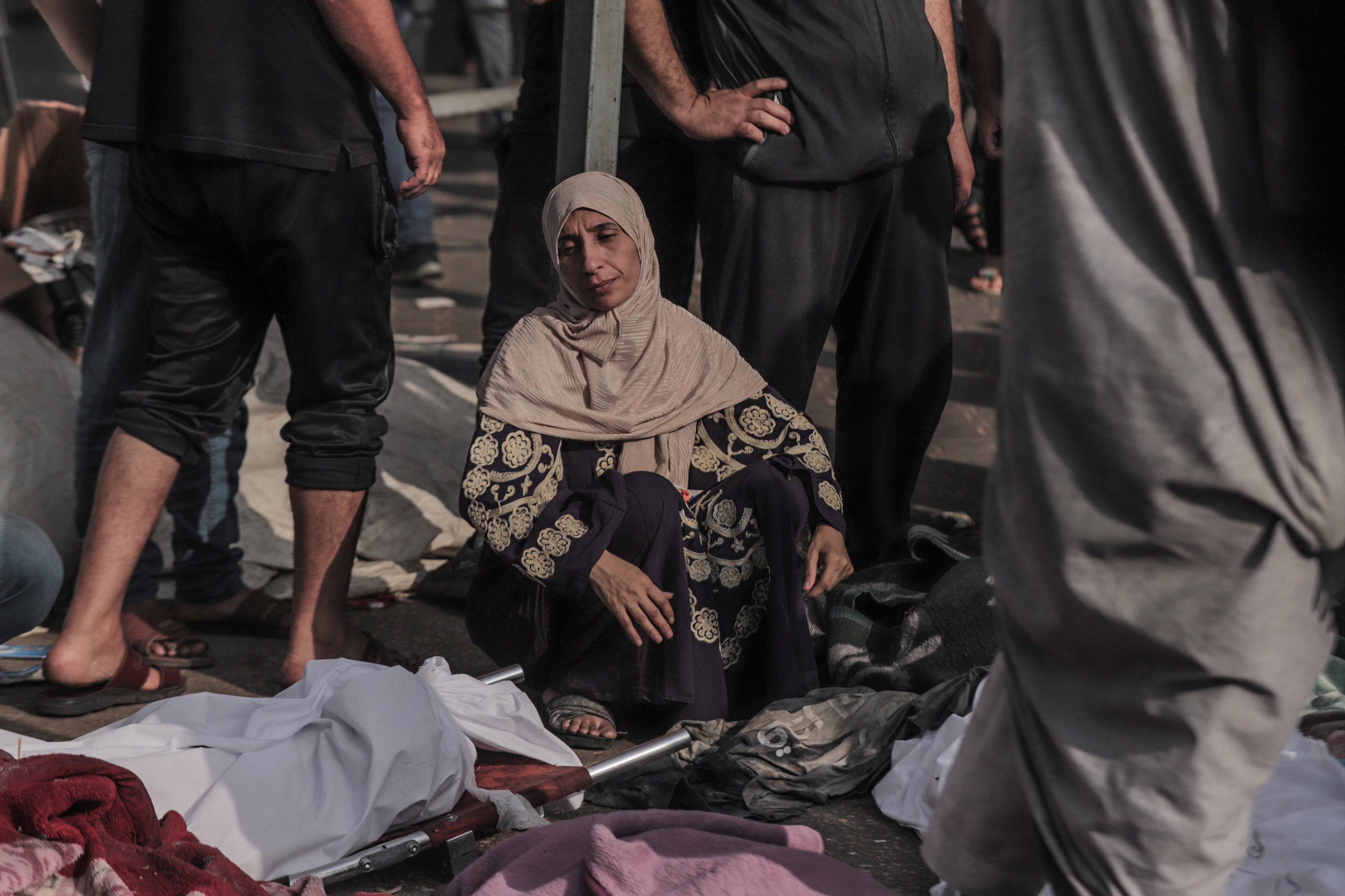 Uma mulher palestina inspeciona os corpos das vítimas do lado de fora do hospital Al-Shifa, na cidade de Gaza, que foram mortas no bombardeio israelense, em 8 de novembro.