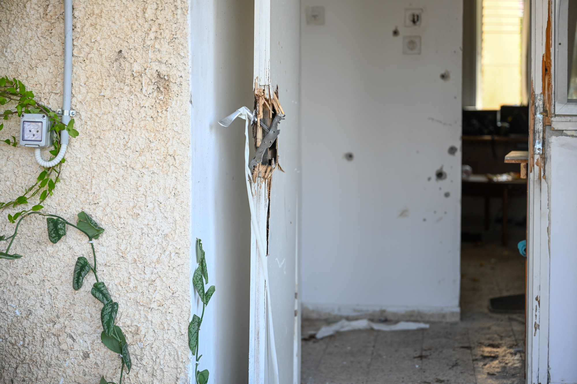 Bullet holes are seen on the walls of a house next to a broken door handle in Kfar Aza on Tuesday.