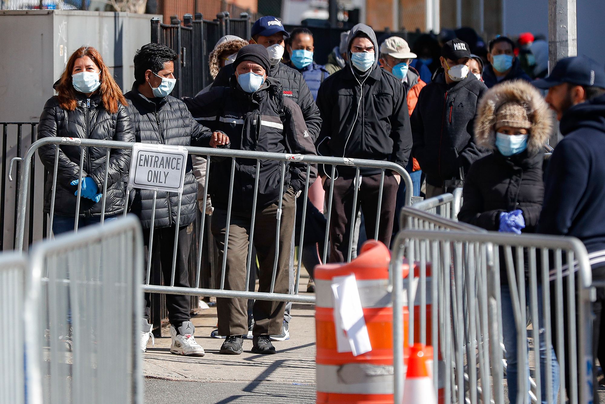 Patients wearing face masks and personal protective equipment wait on line for Covid-19 testing outside Elmhurst Hospital Center, Friday, March 27, in New York. 