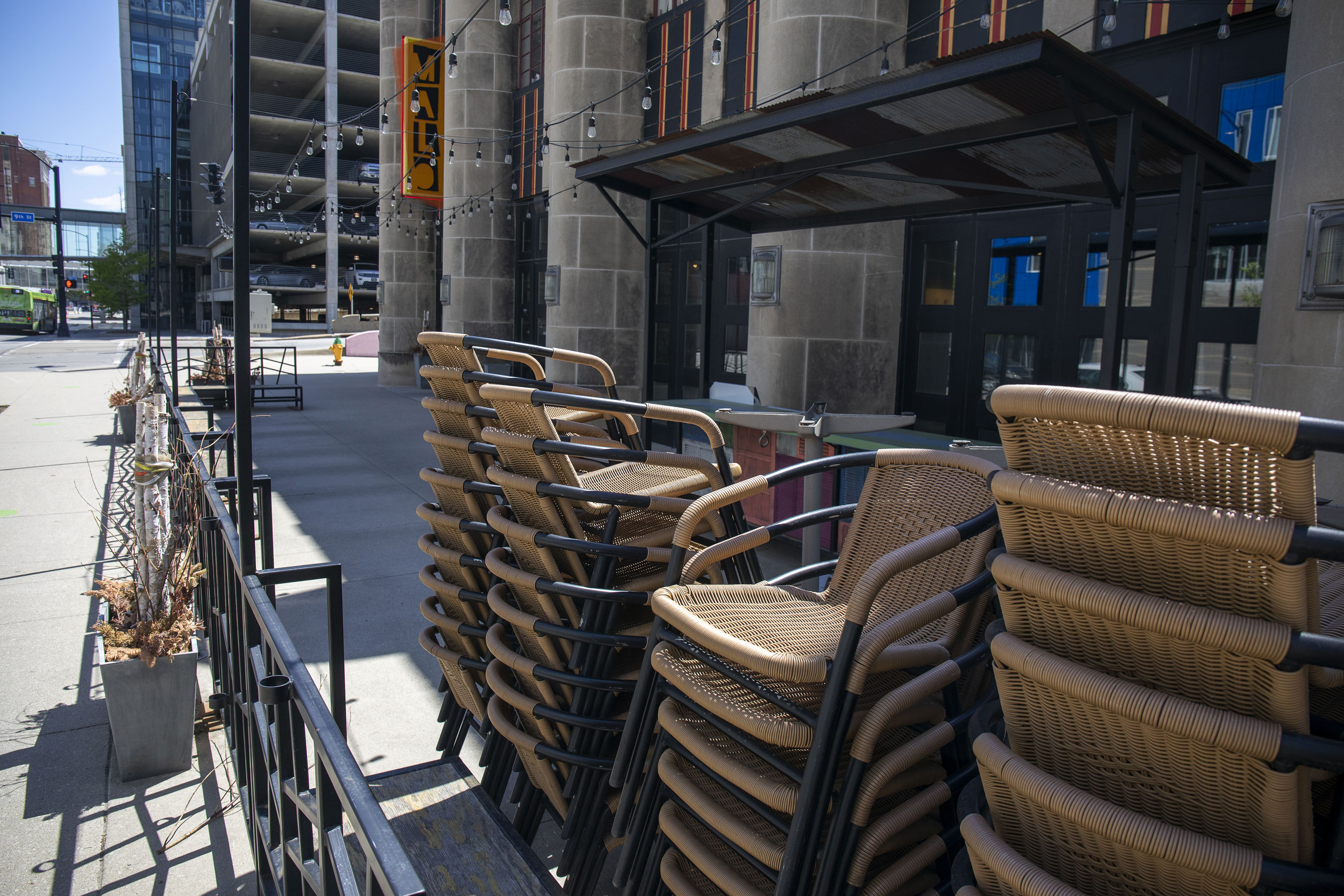 Patio furniture sits stacked outside a closed restaurant in downtown Des Moines, Iowa, on Friday, May 8.