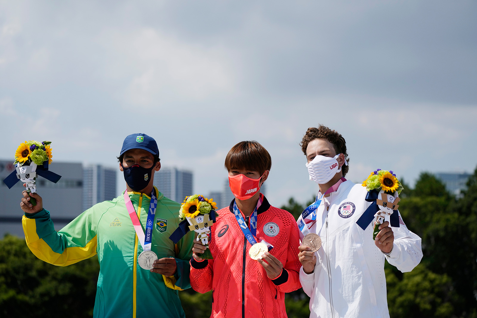 Kelvin Hoefler of Brazil, Yuto Horigome of Japan and Jagger Eton pose after the medal presentation at the men's street skateboarding finals on Sunday, July 25.