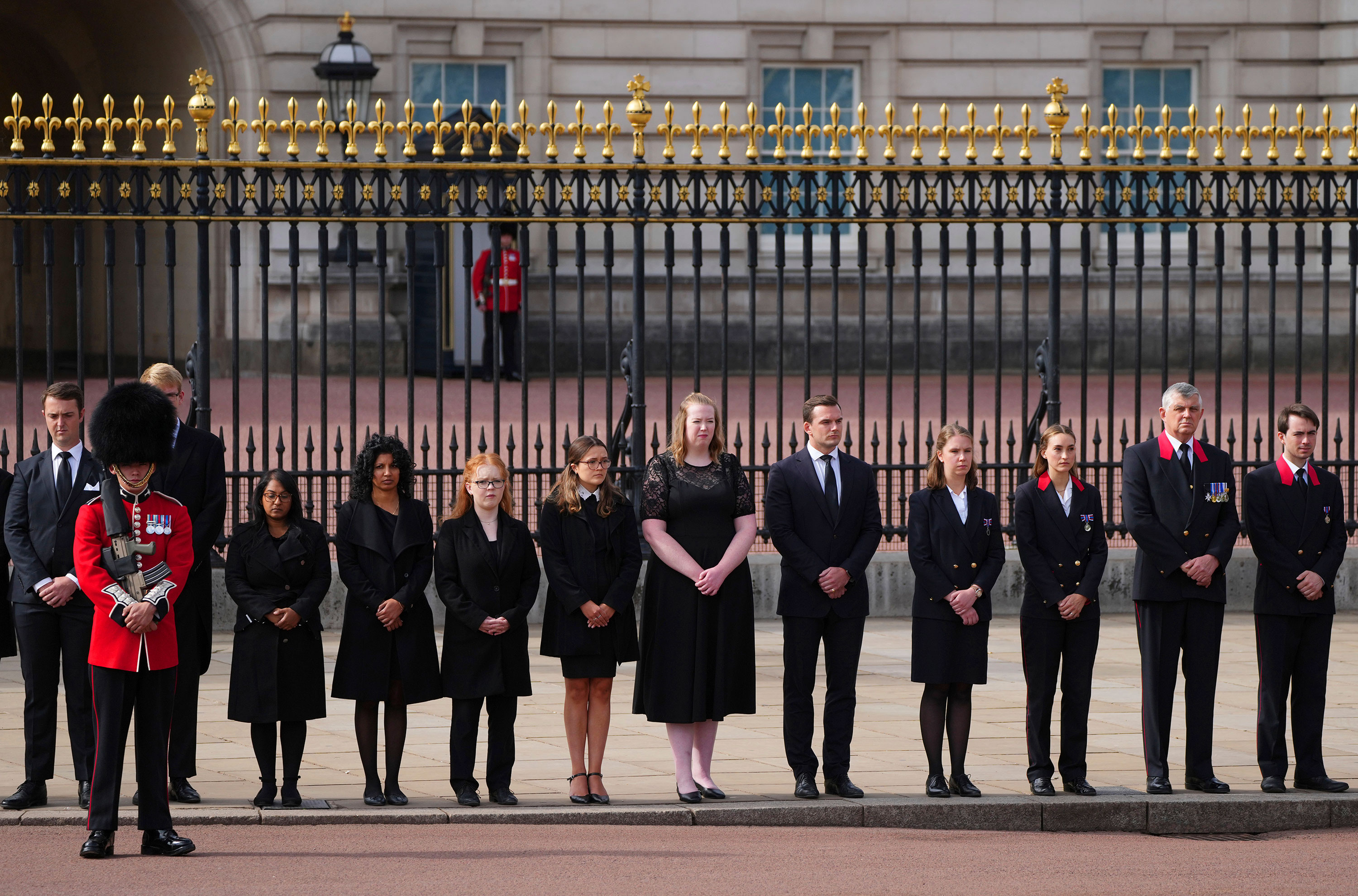 Royal household staff pay their respects outside Buckingham Palace.