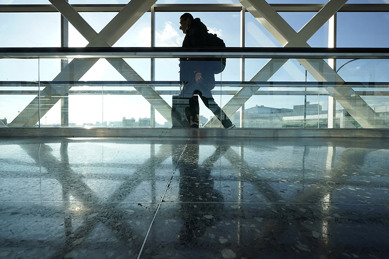 A traveler walks along a moving walkway between terminals at Logan International Airport in Boston, the day before Thanksgiving, on Nov. 23.