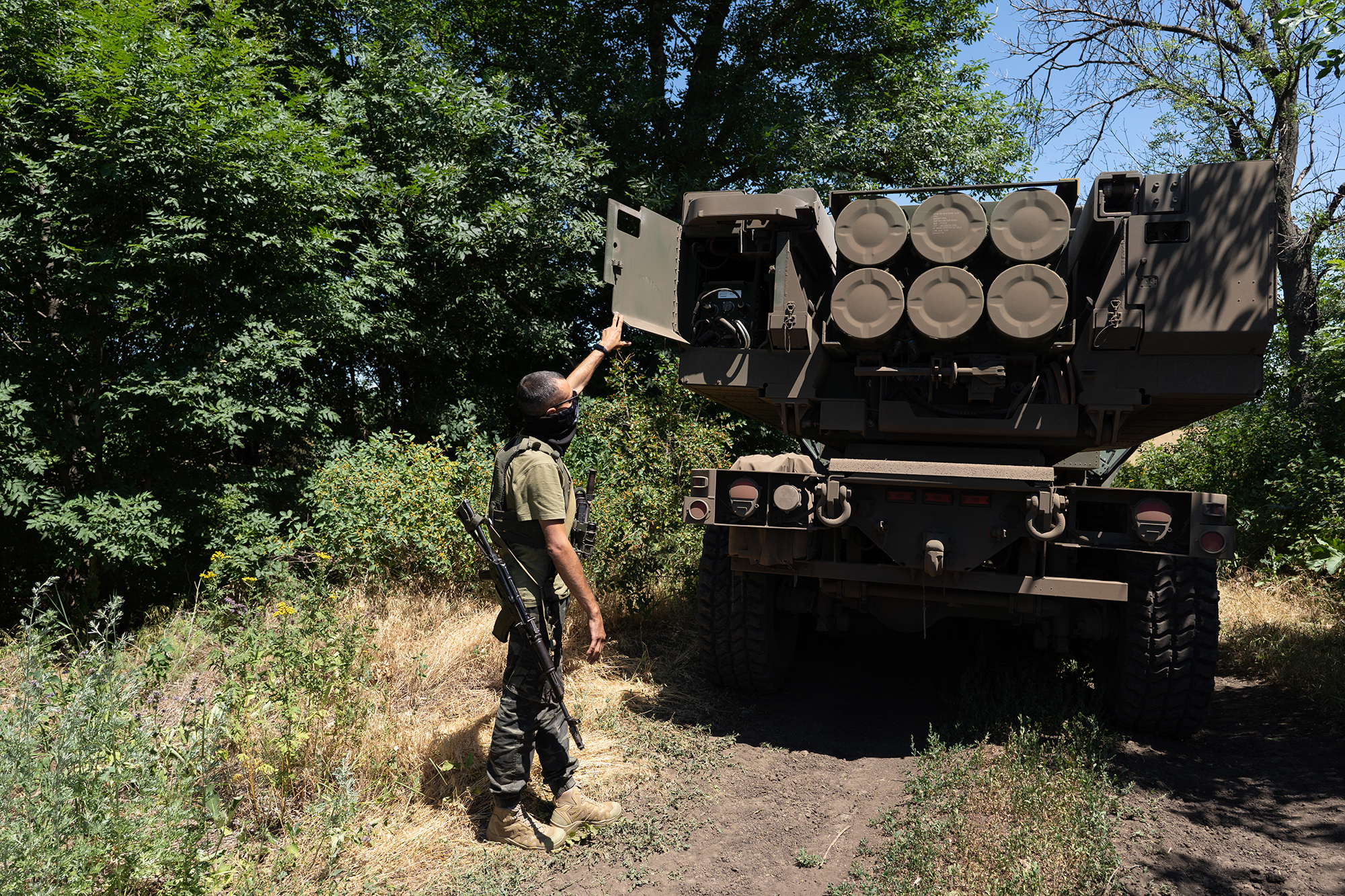 In this July 1, 2022 photo, a Ukrainian commander shows the rockets on a HIMARS vehicle in Eastern Ukraine.