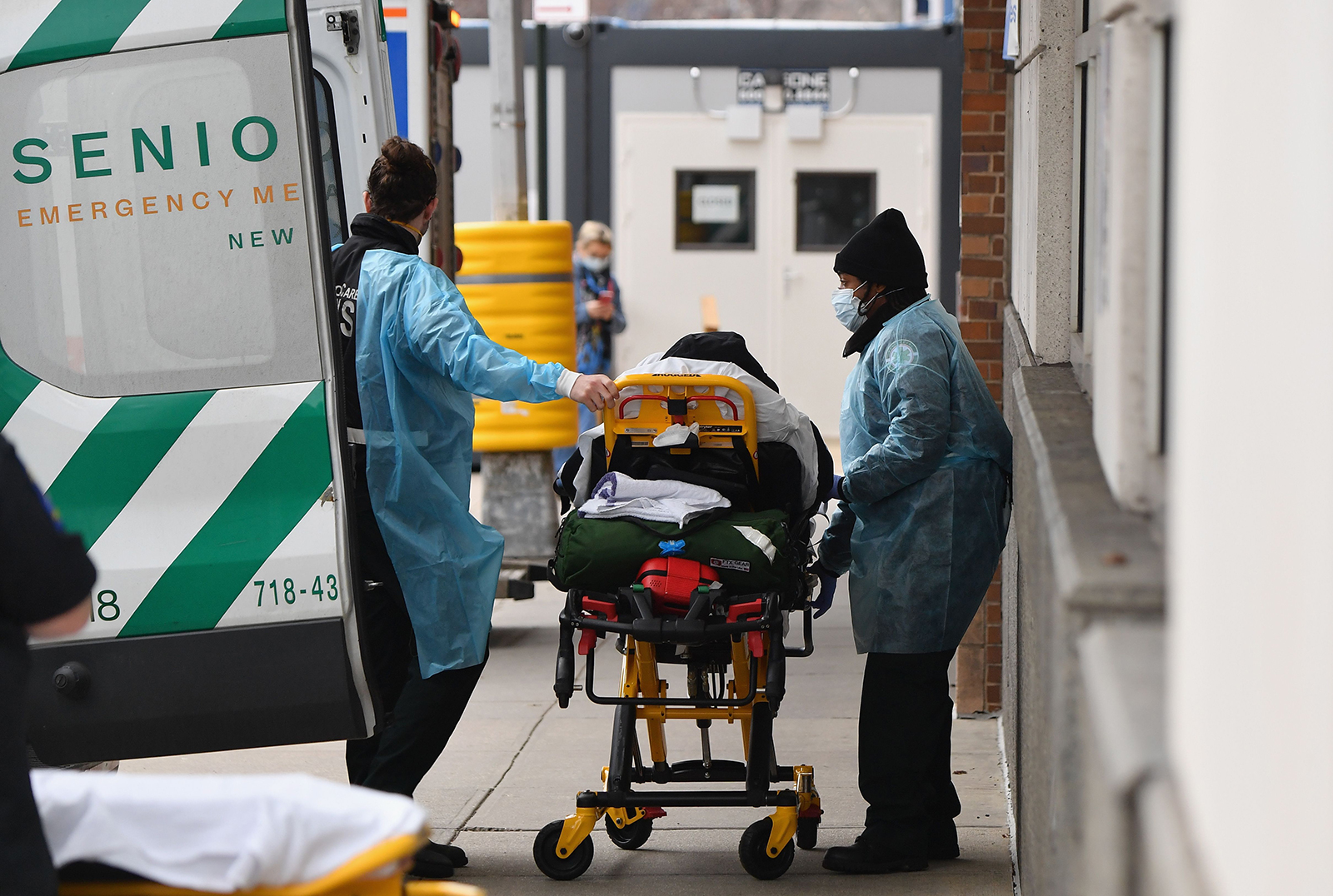 Healthcare workers transport a patient from an ambulance to Maimonides Medical Center, a hospital in the Brooklyn neighborhood of Borough Park, on January 4, 20 in New York City.
