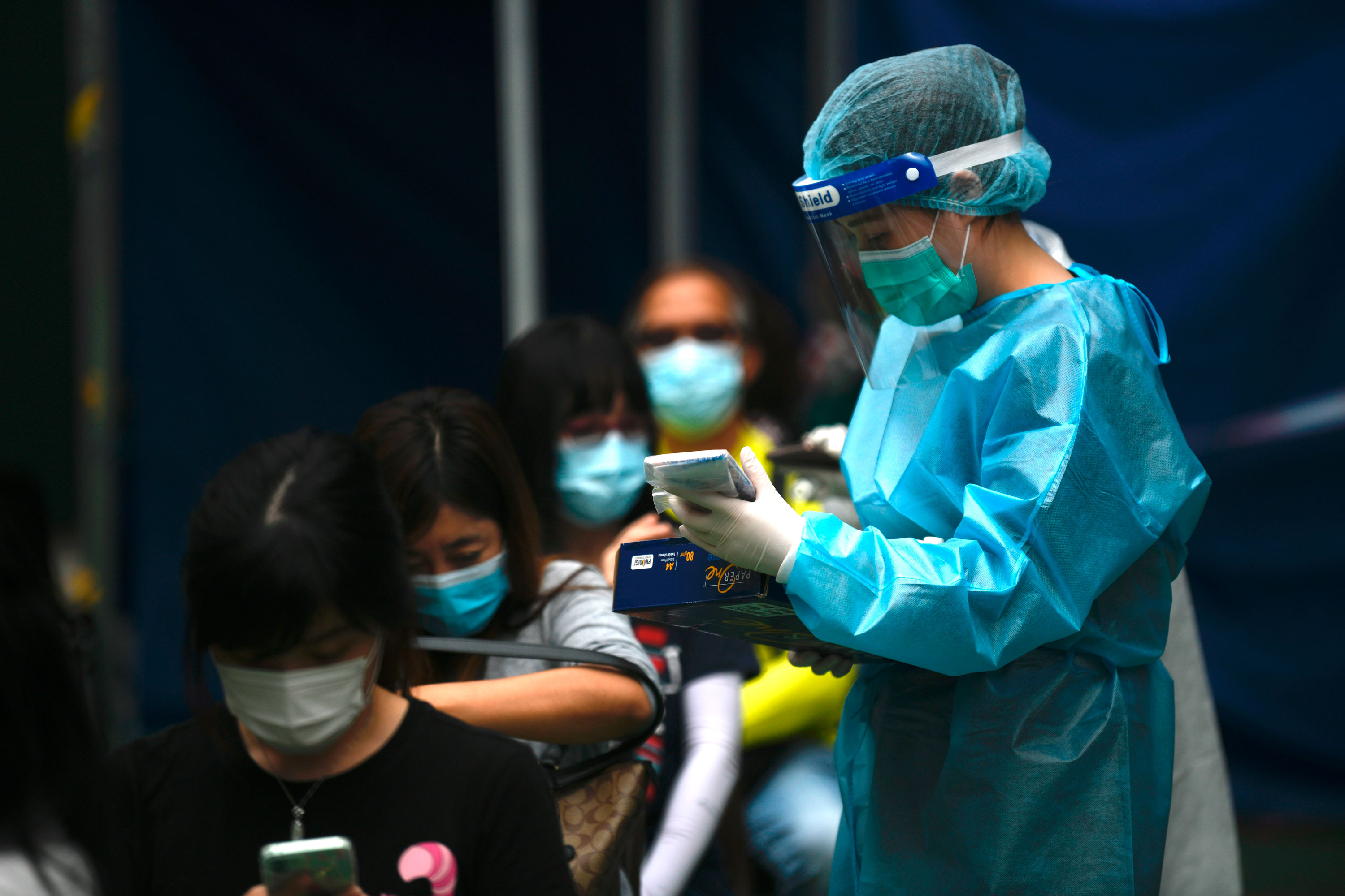A worker in Hong Kong attends to people in line at a Covid-19 testing center on November 24.