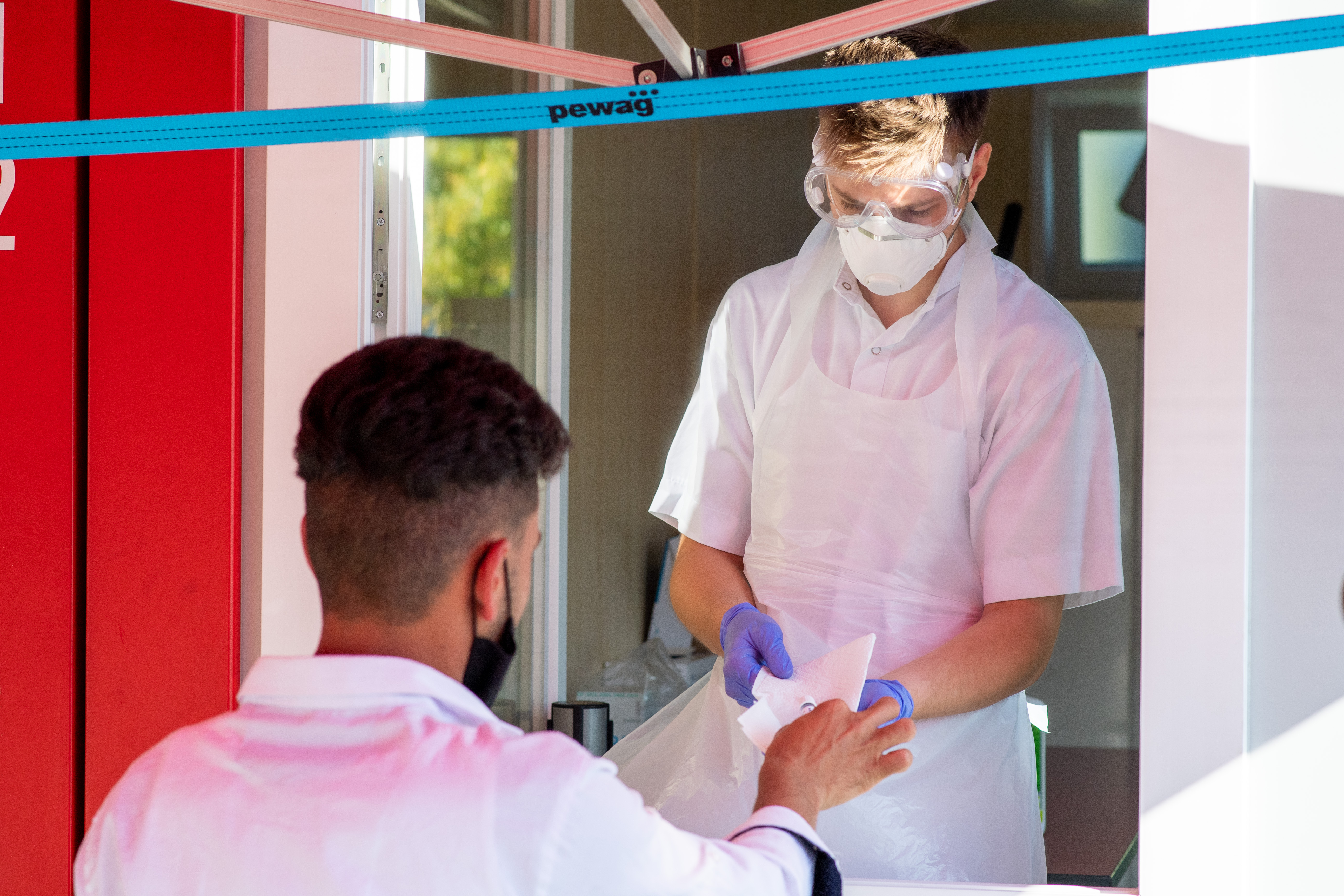 A man in Vienna, Austria, hands his Covid-19 testing sample to an employee at a coronavirus testing center on September 14.