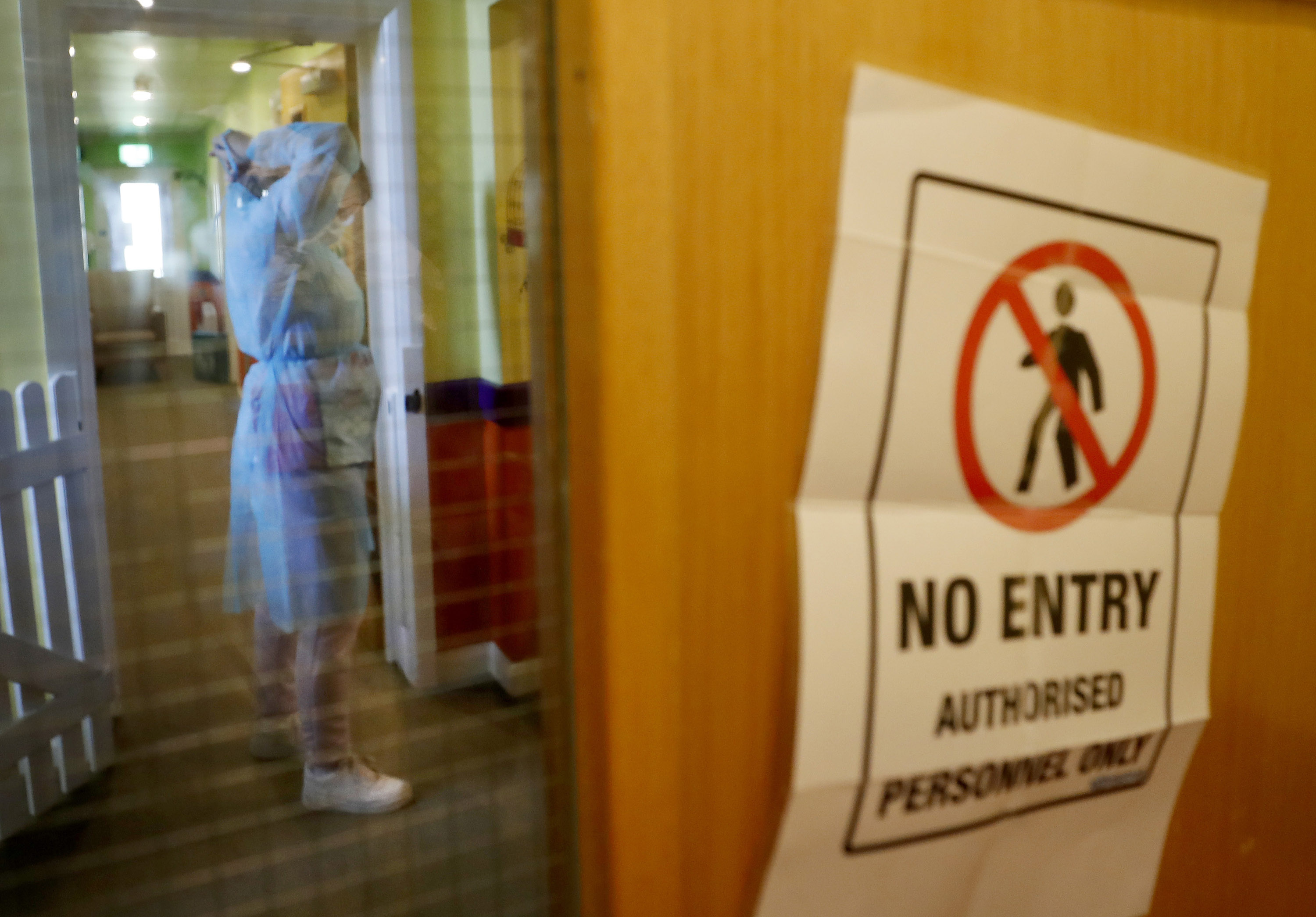 A nurse puts on personal protective equipment (PPEclothing behind closed doors in the red zone.at the Wren Hall care home in Nottingham, Monday, April 20, 2020, 