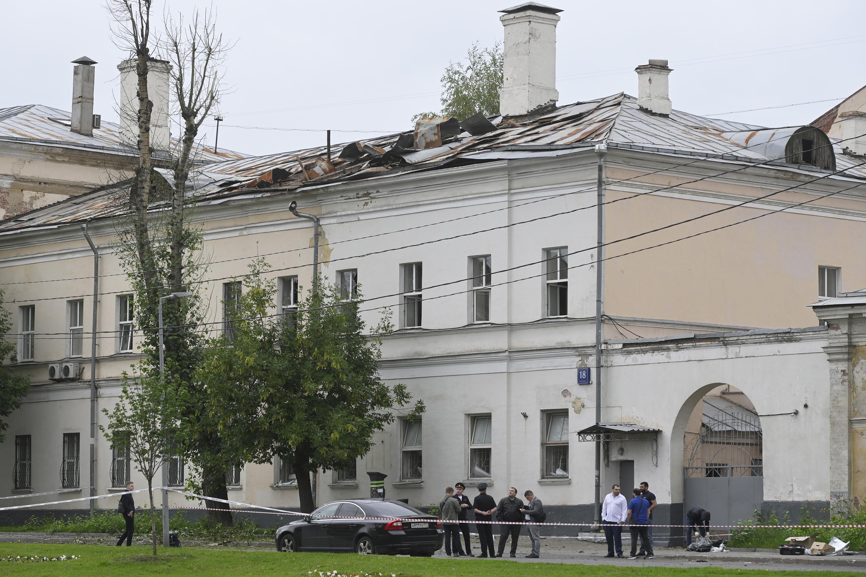 Investigators examine an area next to a damaged building after a reported drone attack in Moscow, Russia, on Monday, July 24.