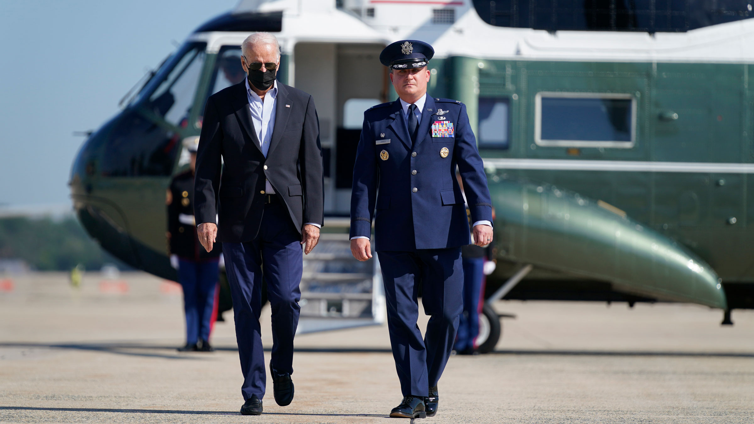 President Joe Biden is escorted Tuesday by Col. Matthew E. Jones, commander of the 89th Airlift Wing, before boarding Air Force One at Andrews Air Force Base in Maryland.