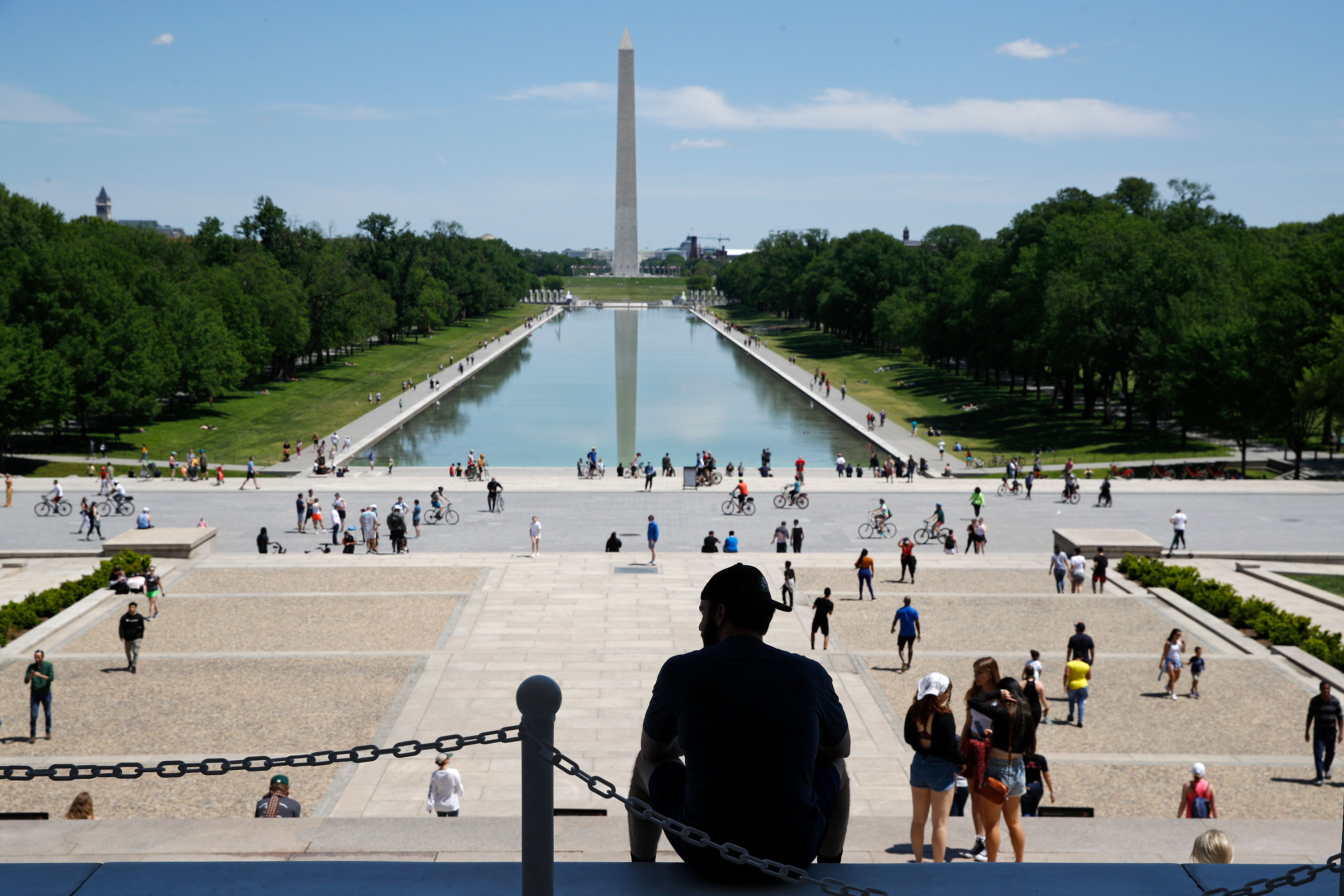 A man sits on the top step of the Lincoln Memorial as people gather by the Lincoln Memorial Reflecting Pool in Washington, on May 2.