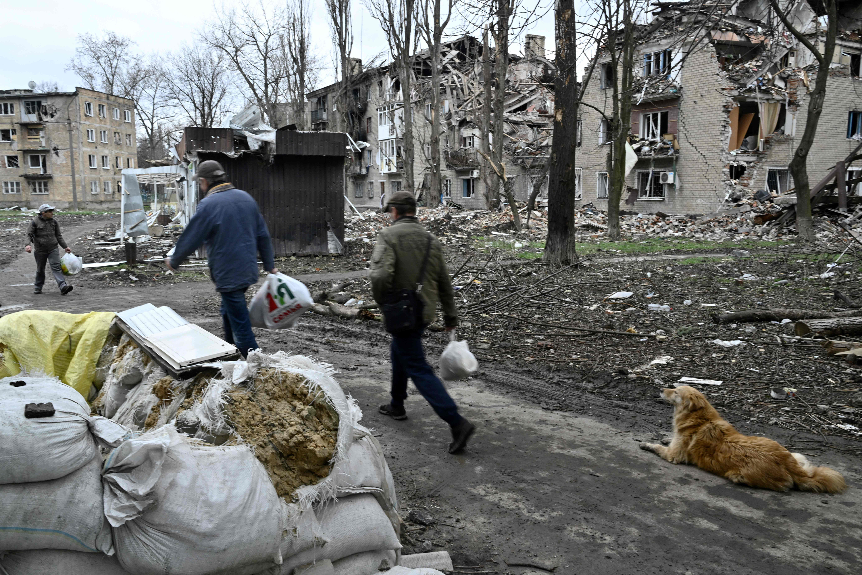 Local residents walk past a destroyed building in Avdiivka, Ukraine, on April 4. 