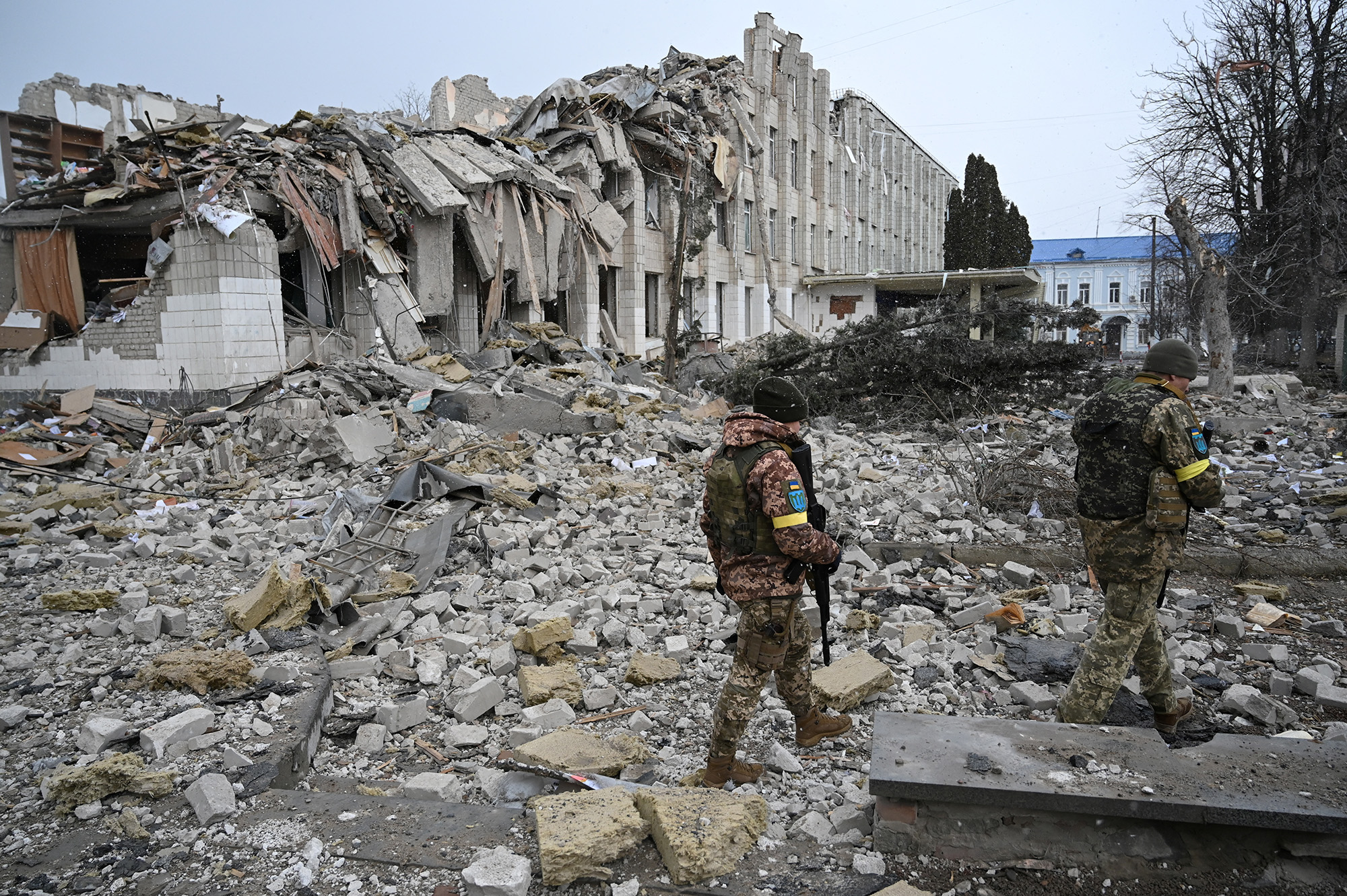 Ukrainian service members walk near a school building destroyed by shelling in Zhytomyr, Ukraine, on March 4.