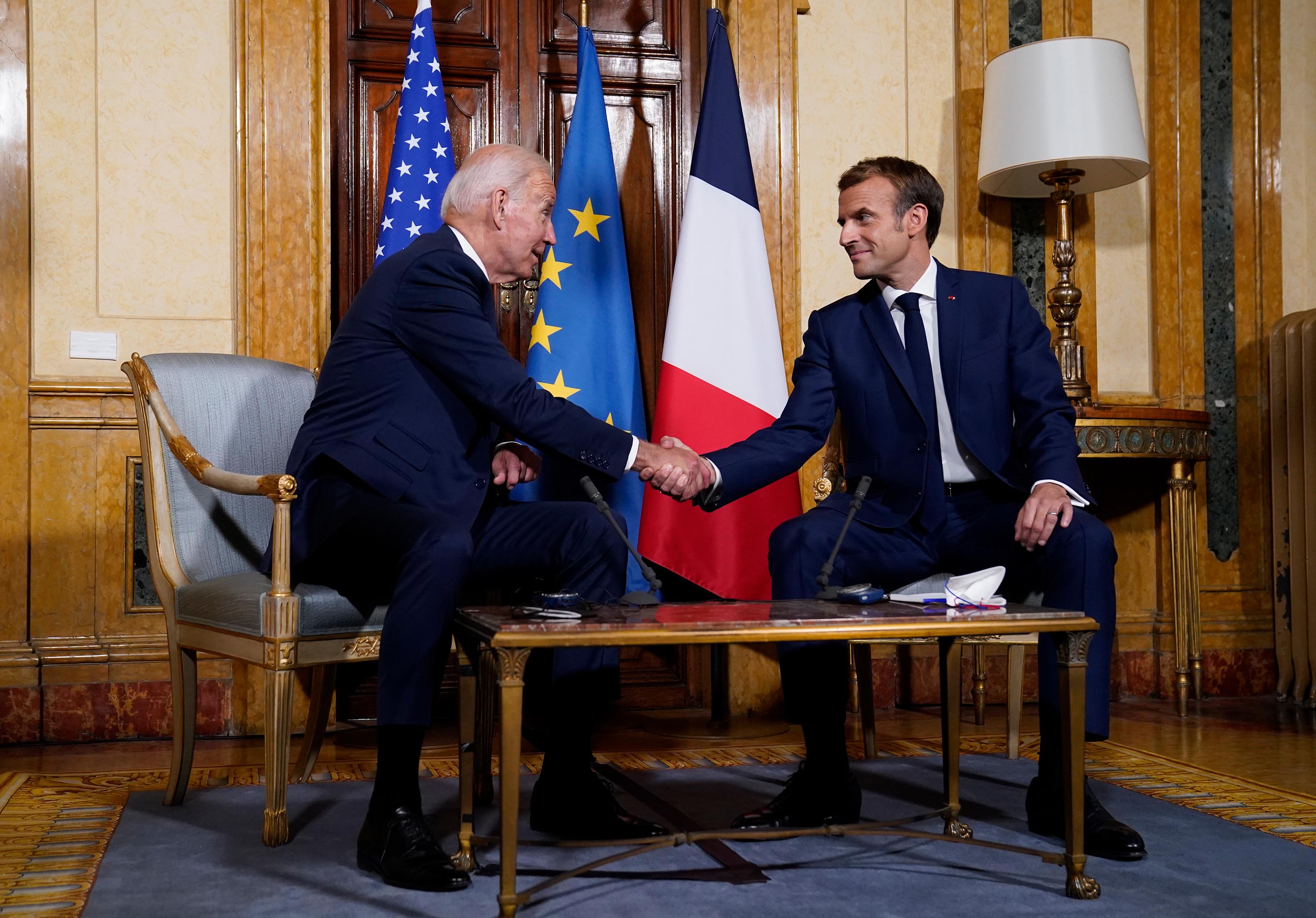 Biden, left, and French President Emmanuel Macron shake hands during a meeting at La Villa Bonaparte in Rome, Friday.