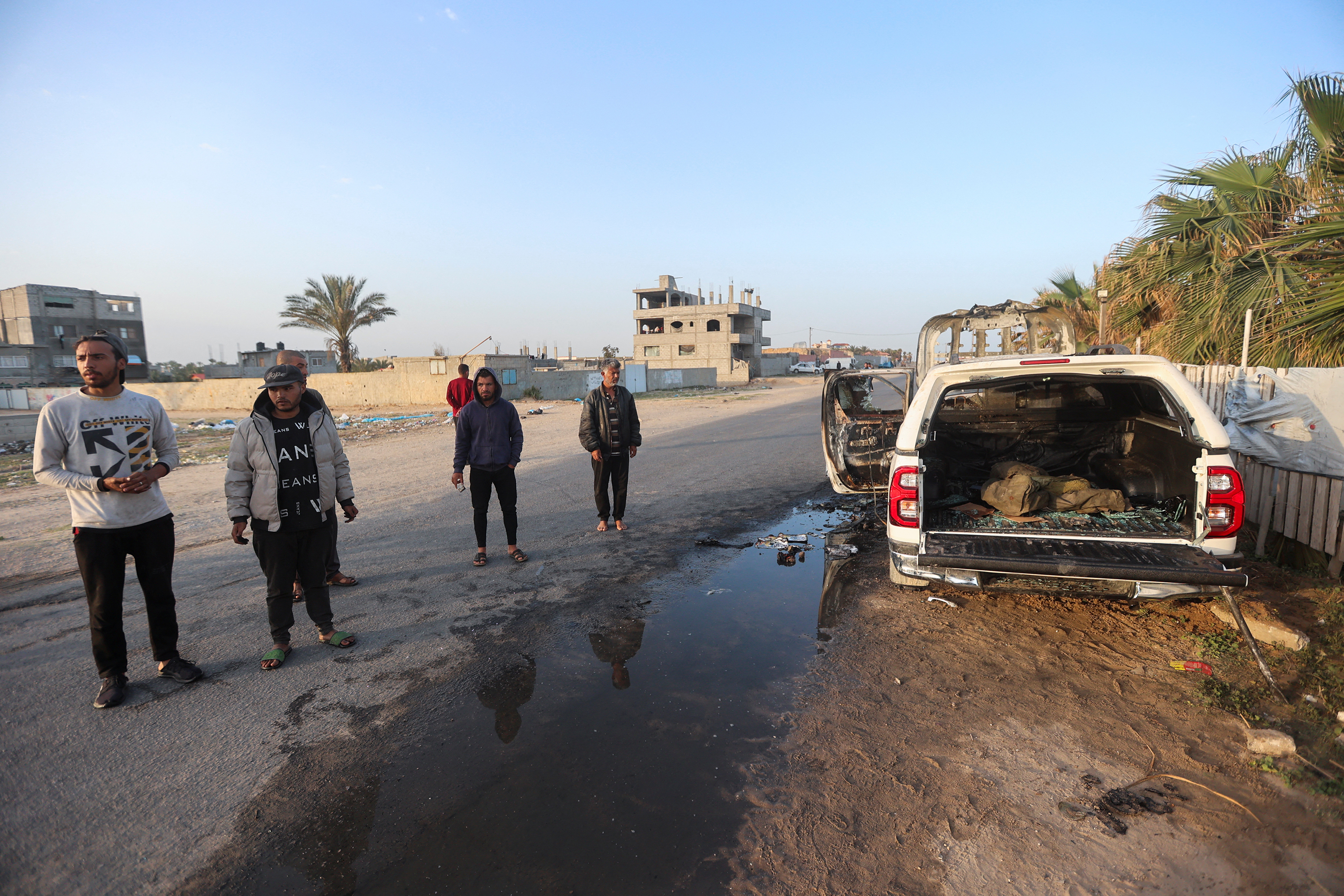 Palestinians stand next to a vehicle where employees from the World Central Kitchen (WCK), including foreigners, were killed in an Israeli airstrike in central Gaza, on April 2.
