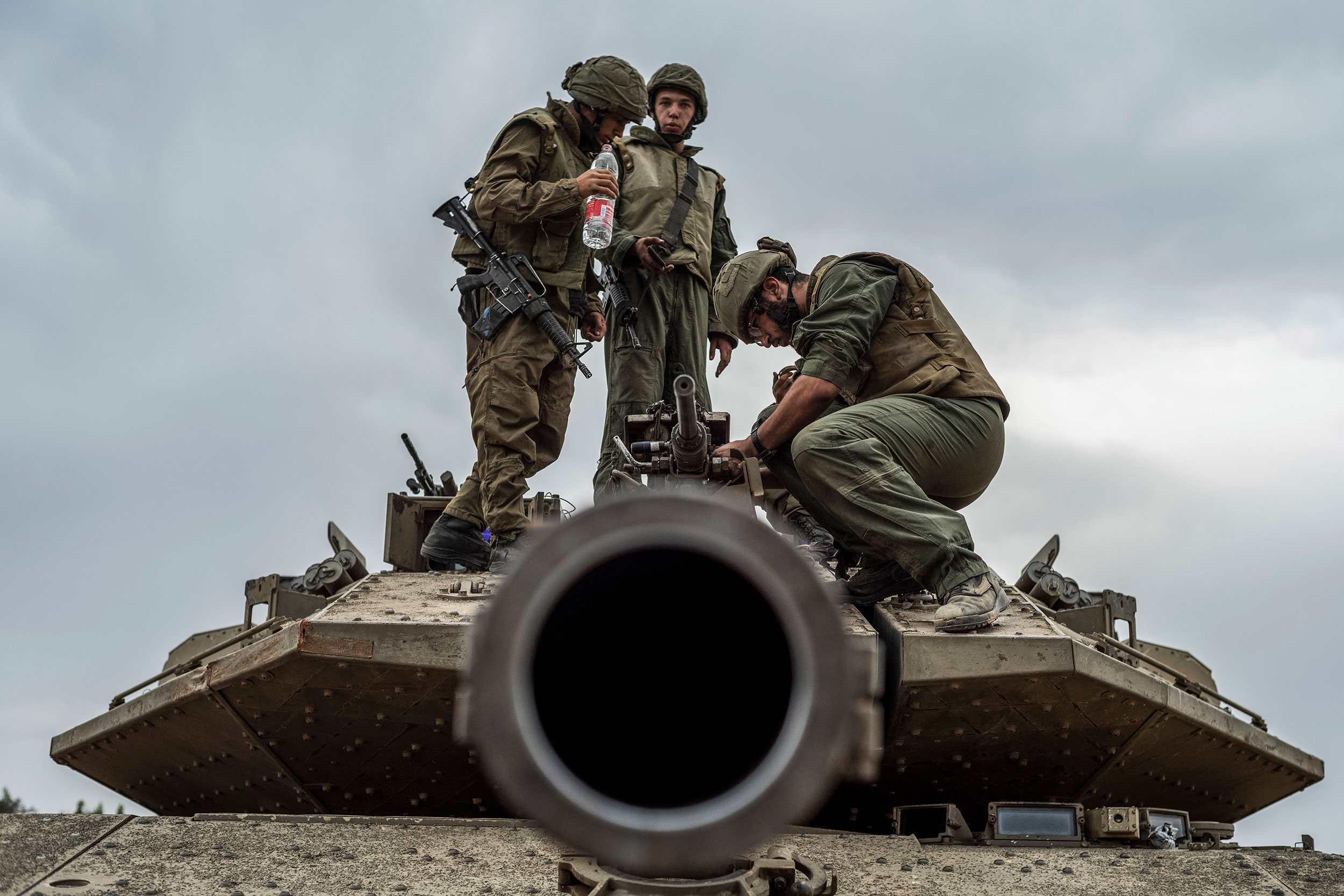 Israeli soldiers work on a tank at the Israel-Gaza border in Sderot, Israel, on October 9, 2023.