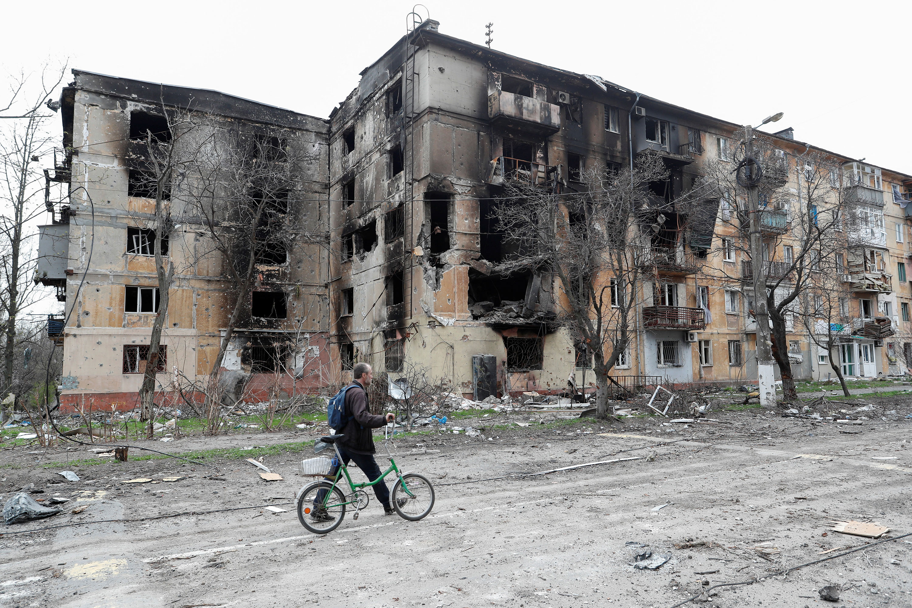 A man walks past a heavily-damaged residential building in Mariupol, Ukraine, on April 18.