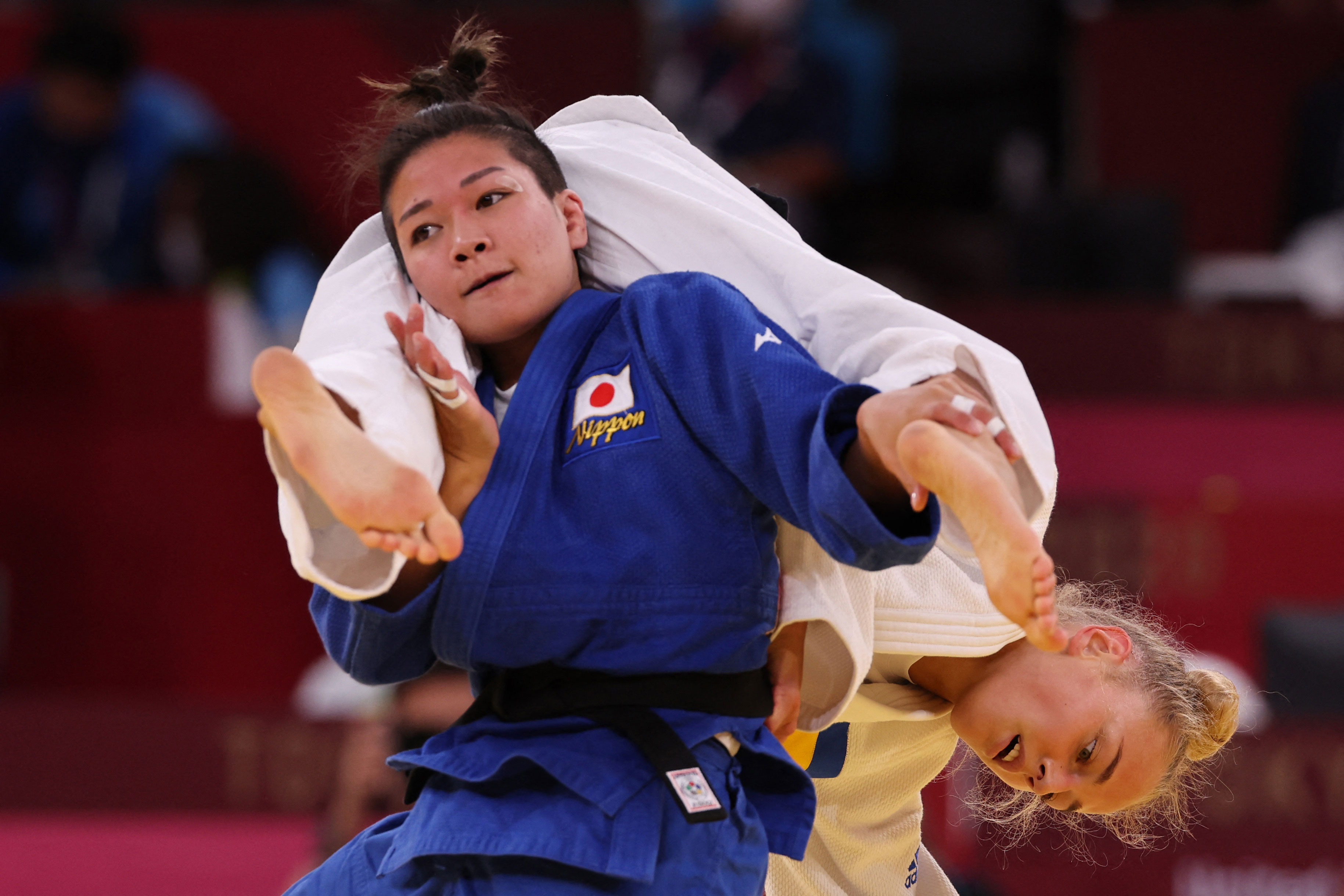 Japan's Funa Tonaki, in blue, competes with Ukraine's Daria Bilodid during their judo women's -48kg semifinal B bout on July 24.