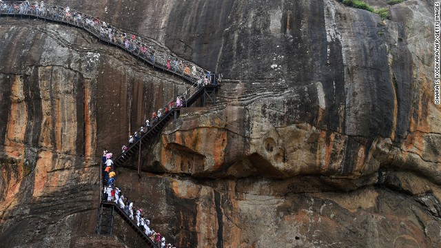 Sri Lankans and tourists climb the 80-metre (600-foot) fortress of Sigiriya rock