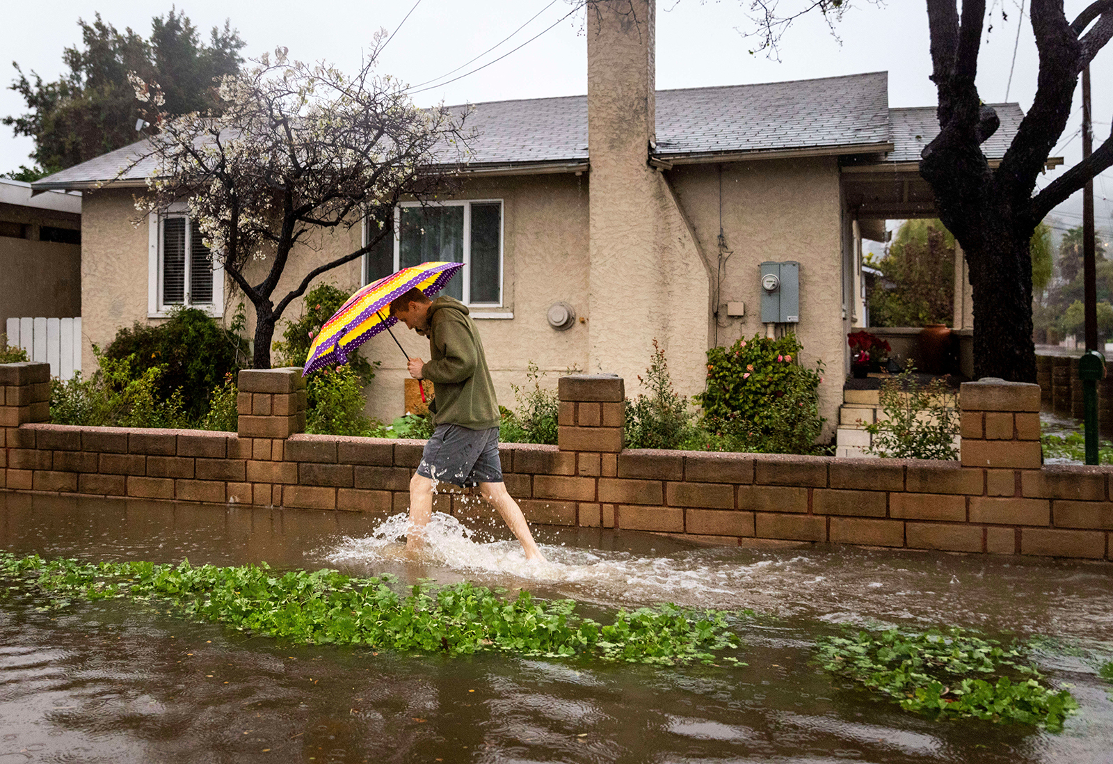 A pedestrian walks through floodwaters during a rainstorm in Santa Barbara, California on February 4.