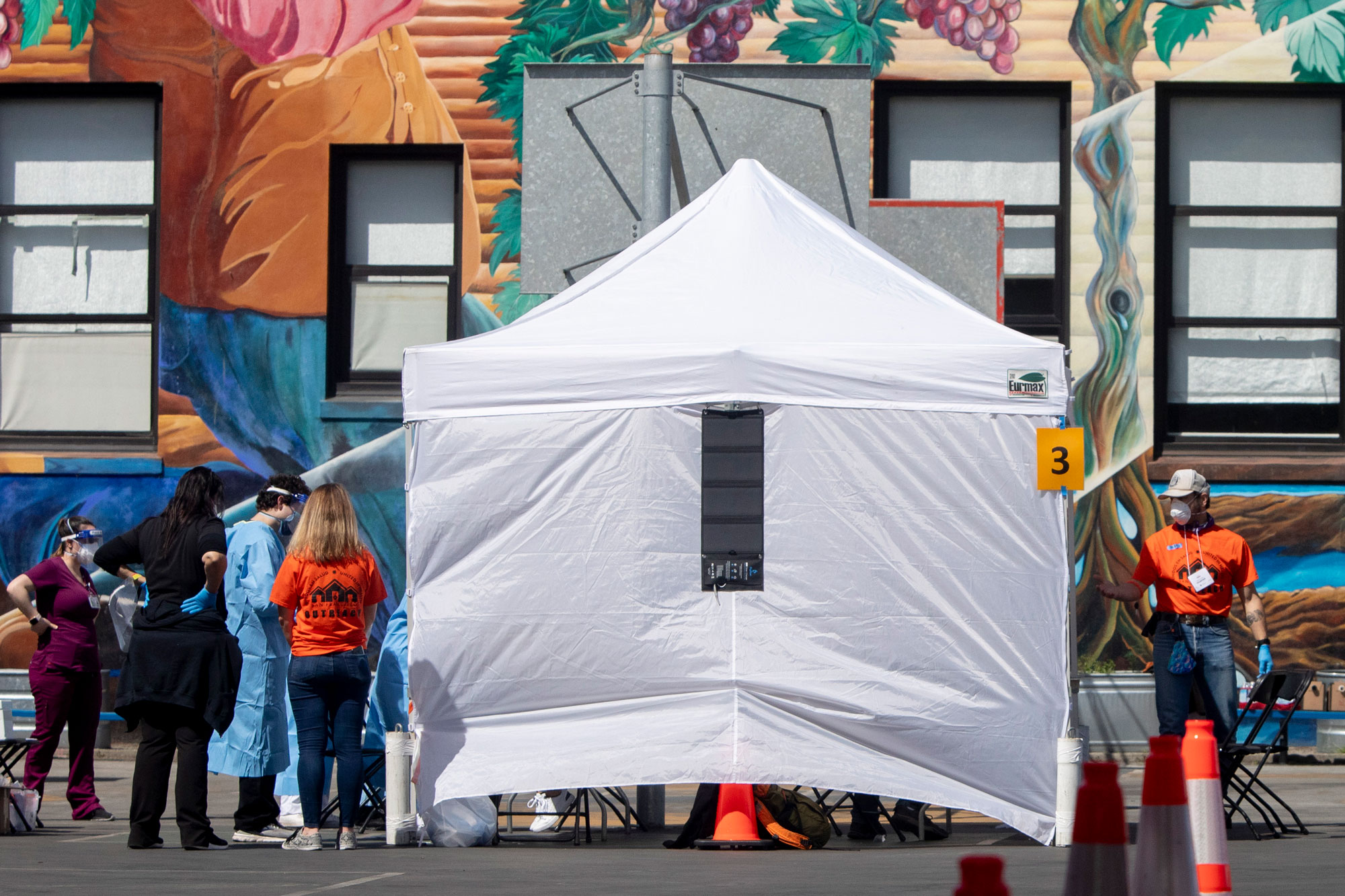 Volunteers and staff with UCSF work to move people through a Coronavirus testing site for Mission district residents at Cesar Chavez Elementary School in San Francisco, on April 25.