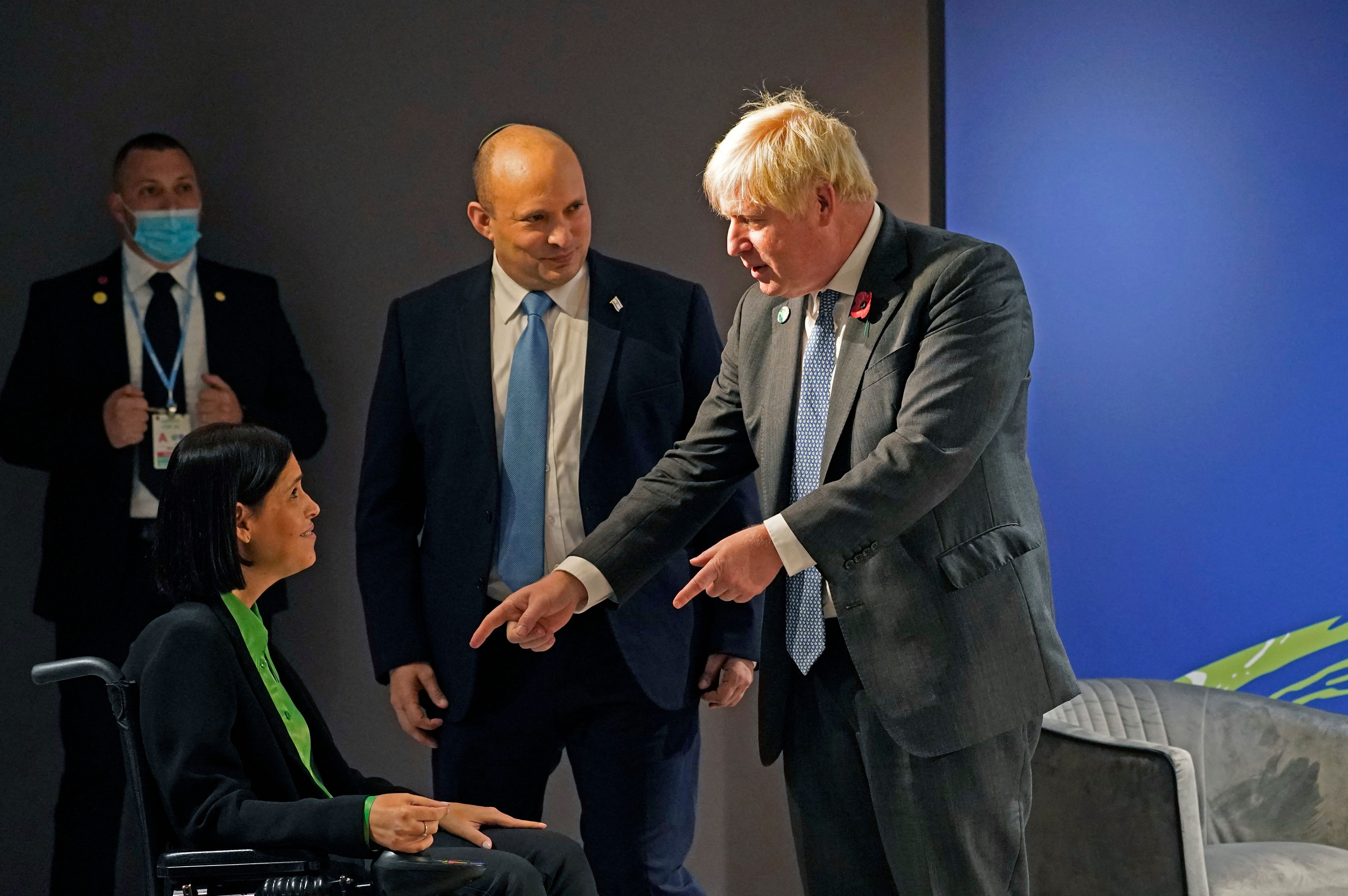 Britain's Prime Minister Boris Johnson, right, is introduced to Israel's Energy Minister Karine Elharrar, as Israel's Prime Minister Naftali Bennett, looks on, during the COP26 Climate Conference at the Scottish Event Campus in Glasgow, Scotland on Tuesday. 