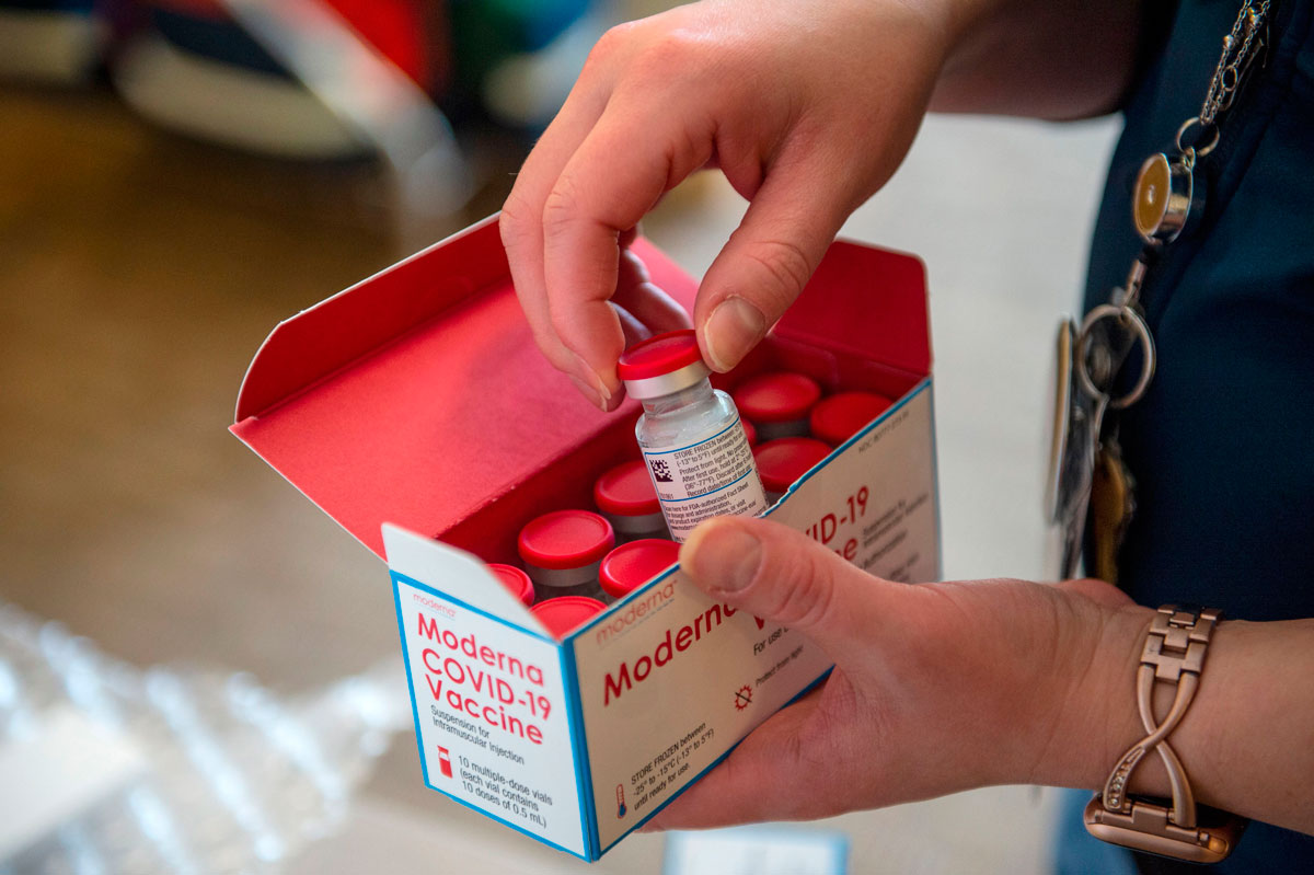 A nurse unpacks a box of Moderna's Covid-19 vaccines at the East Boston Neighborhood Health Center in Boston, Massachusetts on December 24, 2020.