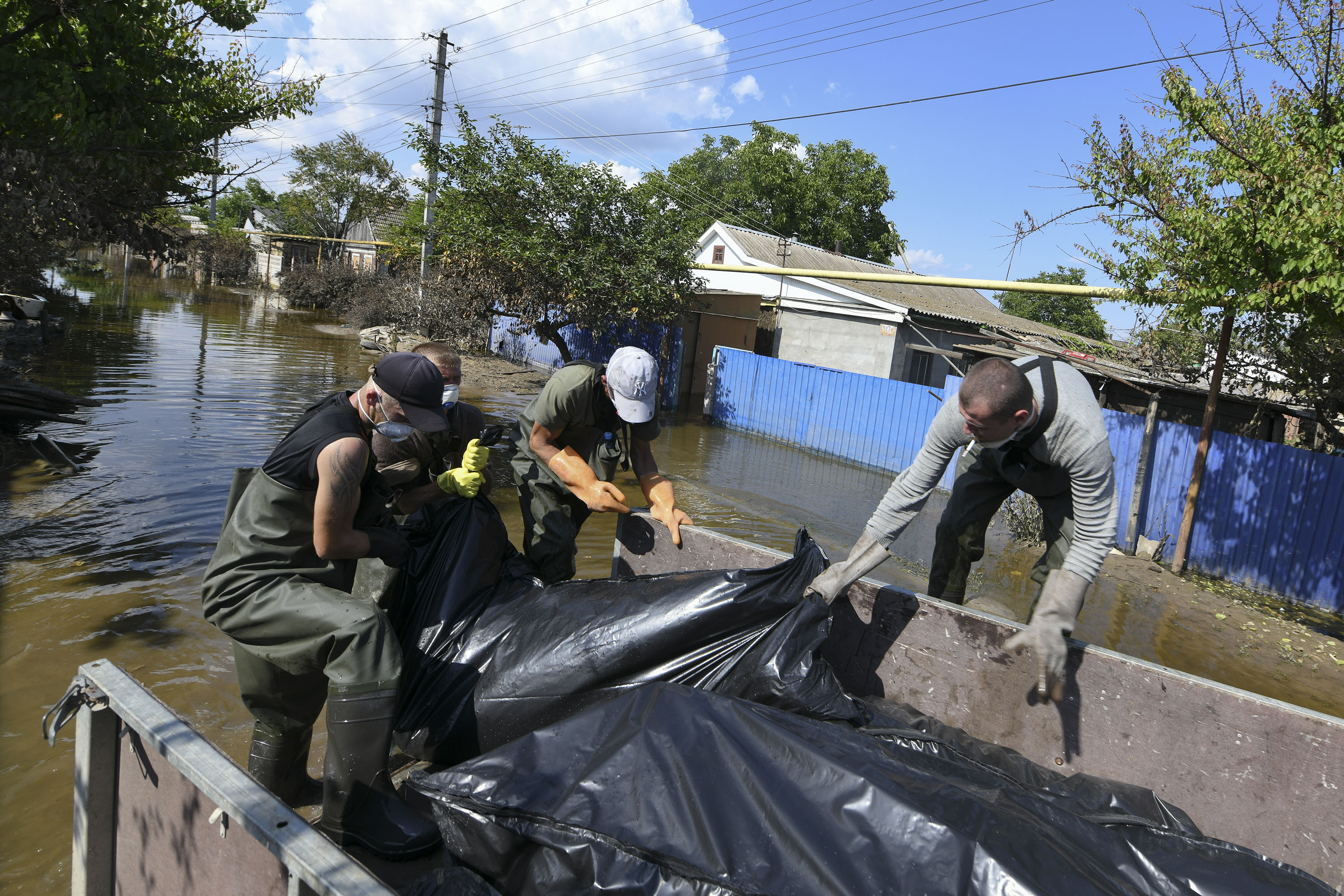 Volunteers and municipal workers recover a body from a flooded house in the Russian-occupied town of Hola Prystan, Ukraine, on June 16, as flood waters recede following the collapse of the Nova Kakhovka dam. 