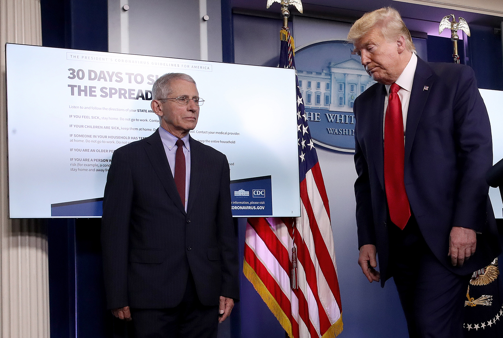 In this March 31 file photo, President Donald Trump departs the daily coronavirus task force briefing while walking past Dr. Anthony Fauci  in the press briefing room at the White House in Washington.