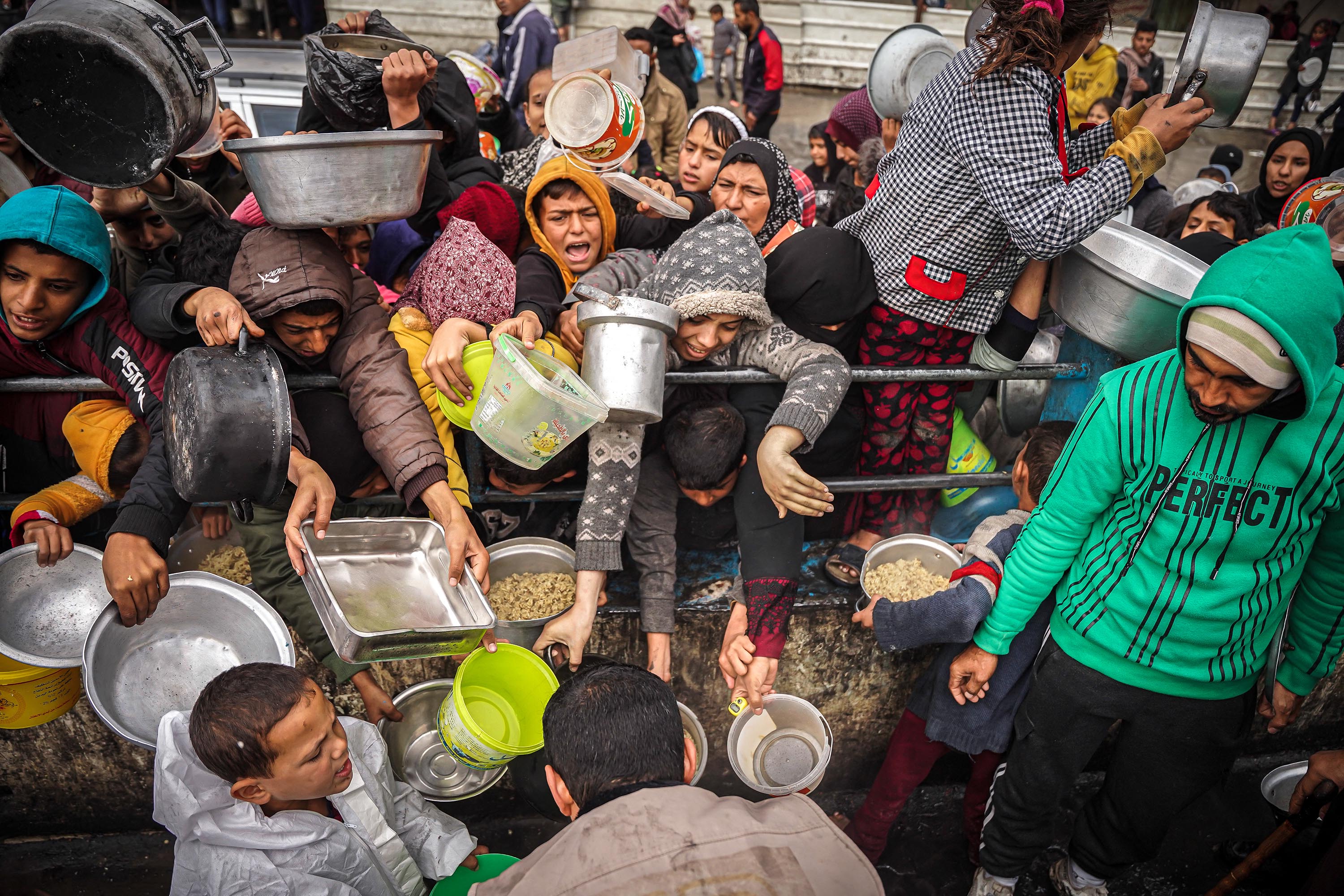 Palestinians wait to receive food at a donation center in a refugee camp in Rafah, Gaza, on January 27. 