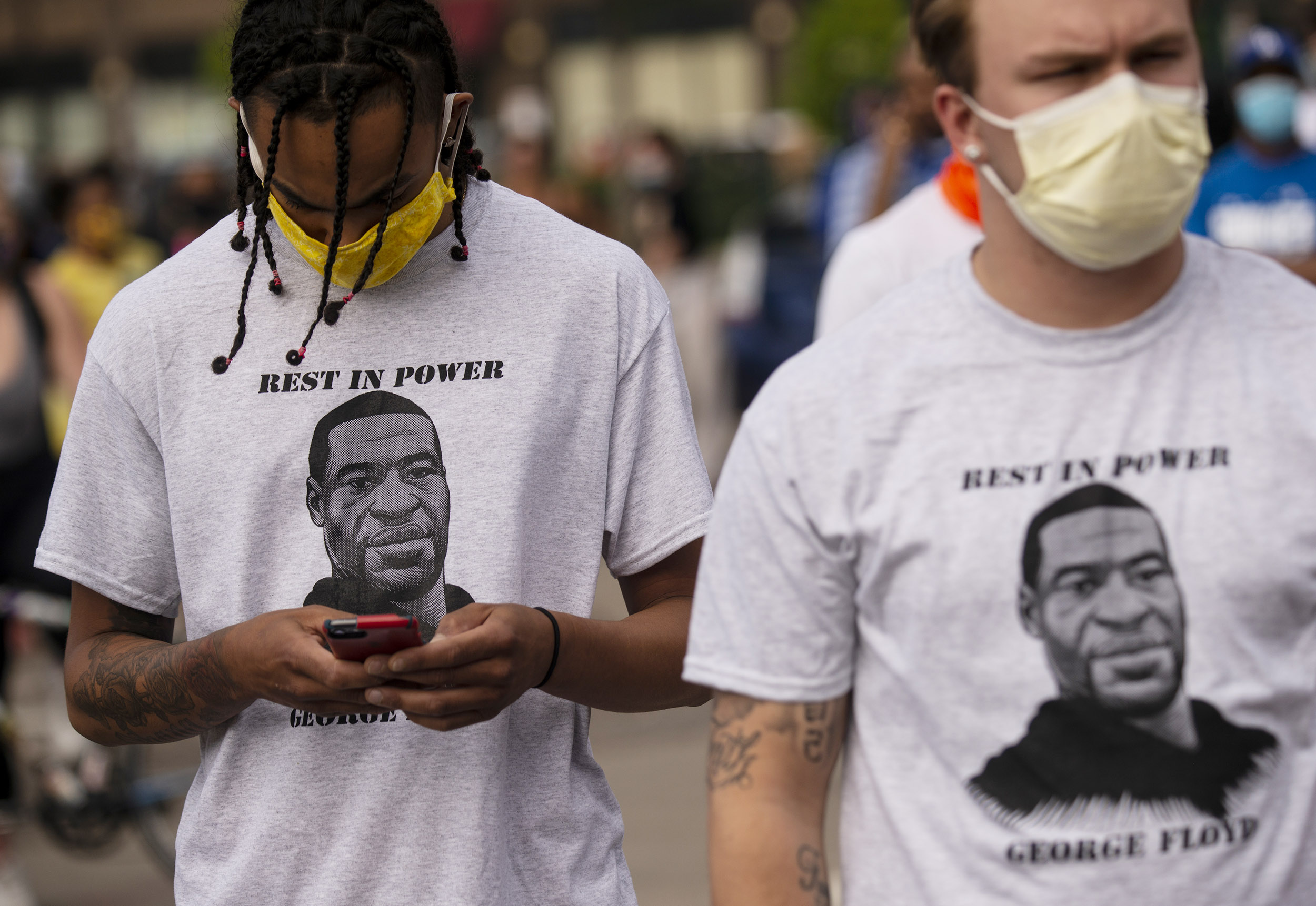 Two men wear shirts stating "Rest in Power George Floyd" outside the Third Police Precinct in Minneapolis, Minnesota, on May 27, 