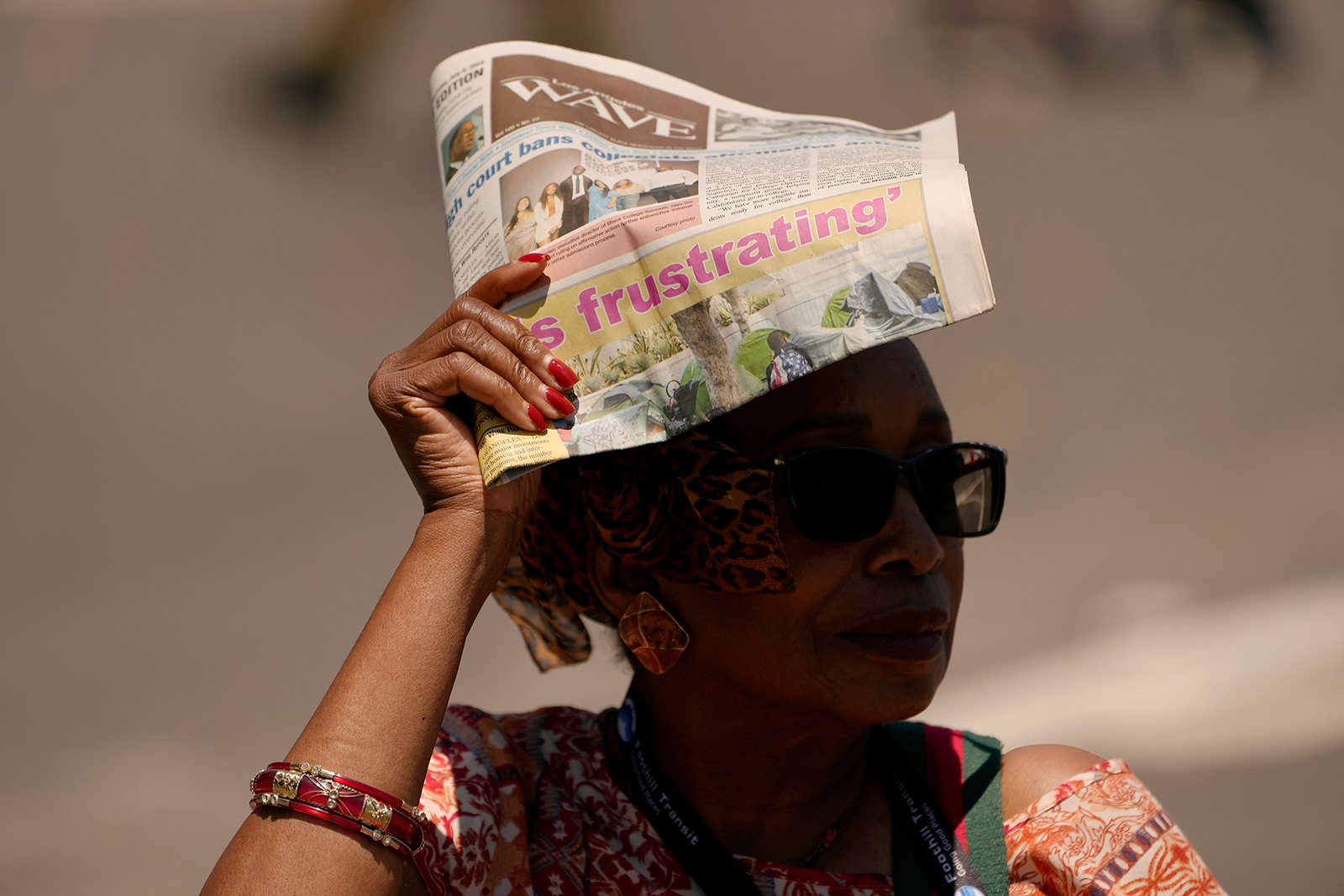 A woman shields herself from the sunlight with a newspaper in Los Angeles on July 15.