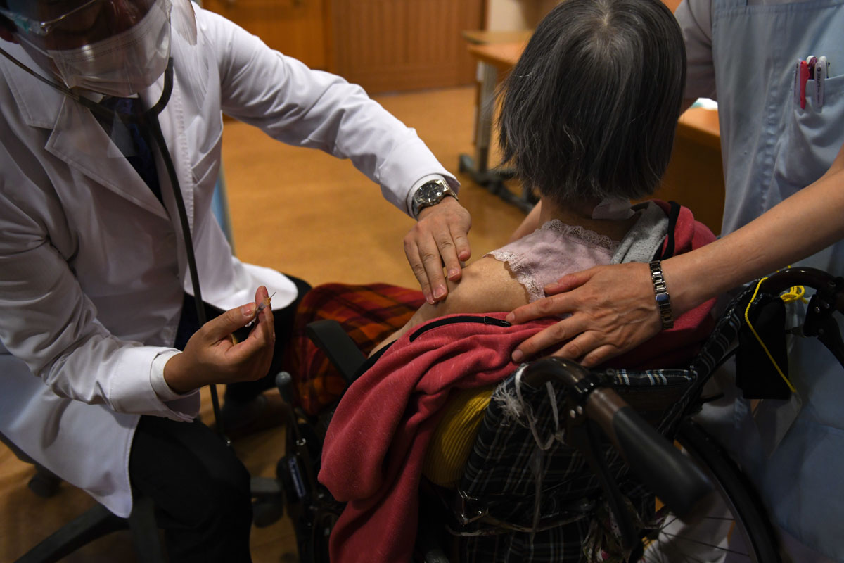 A doctor administers a dose of the Pfizer-BioNTech Covid-19 vaccine at a nursing home in Kanagawa prefecture, Japan, on April 12.