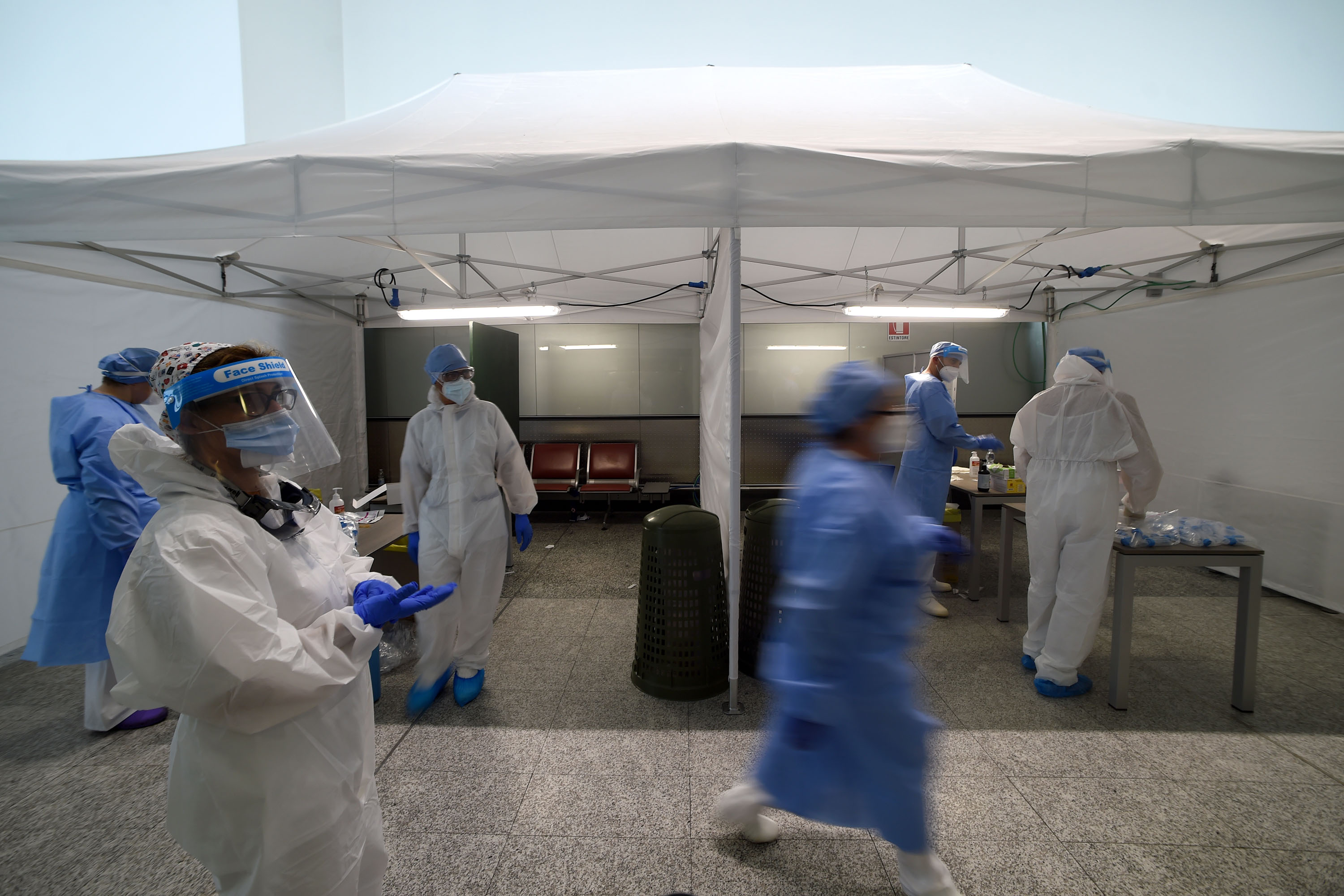 Healthcare professionals work to test travelers for Covid-19 at Malpensa Airport in Somma Lombardo, Italy, on August 20.