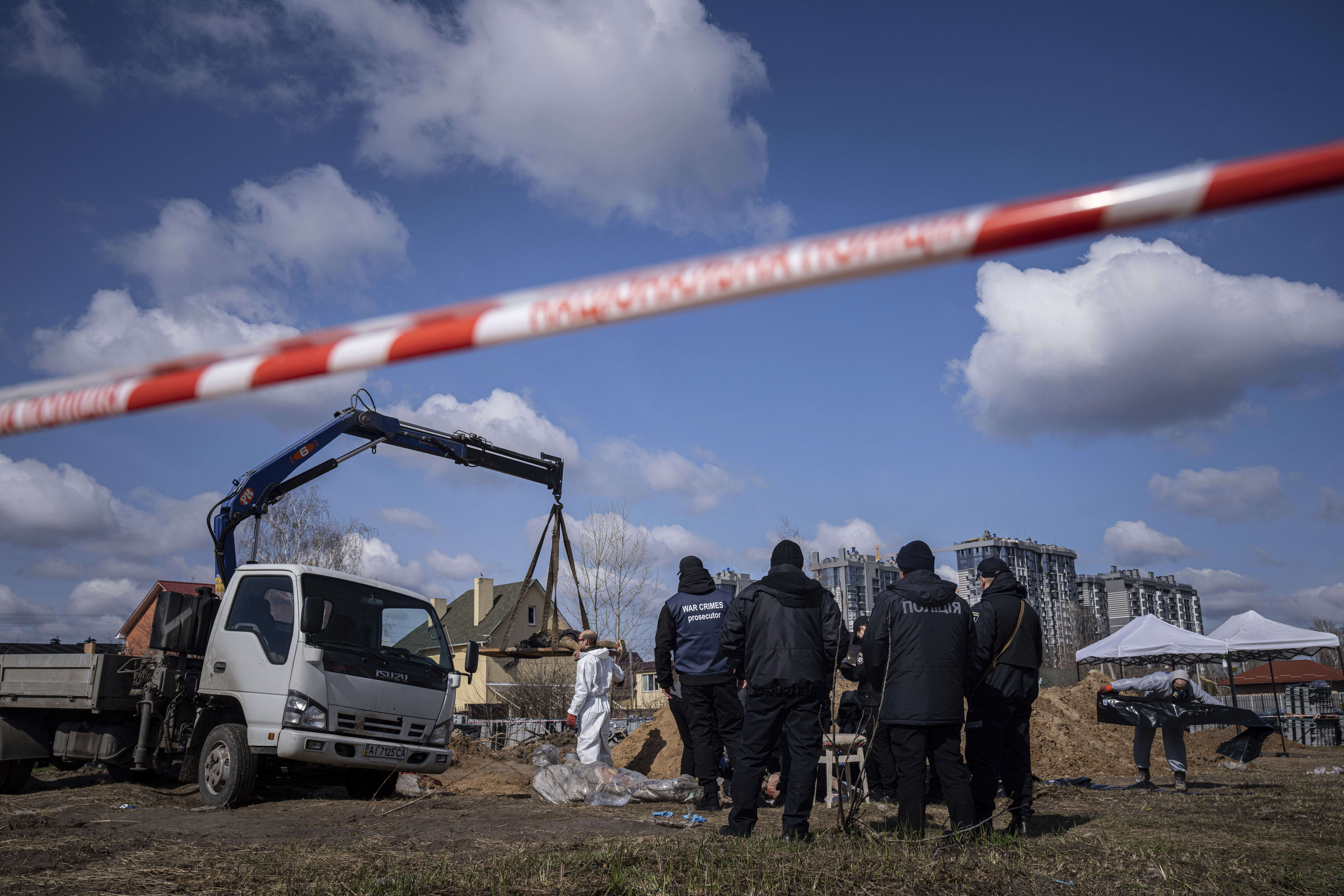 Forensic scientists and police inspect the bodies of local residents after removing them from a mass grave in Bucha, on the outskirts of Kyiv, Ukraine, on April 11.