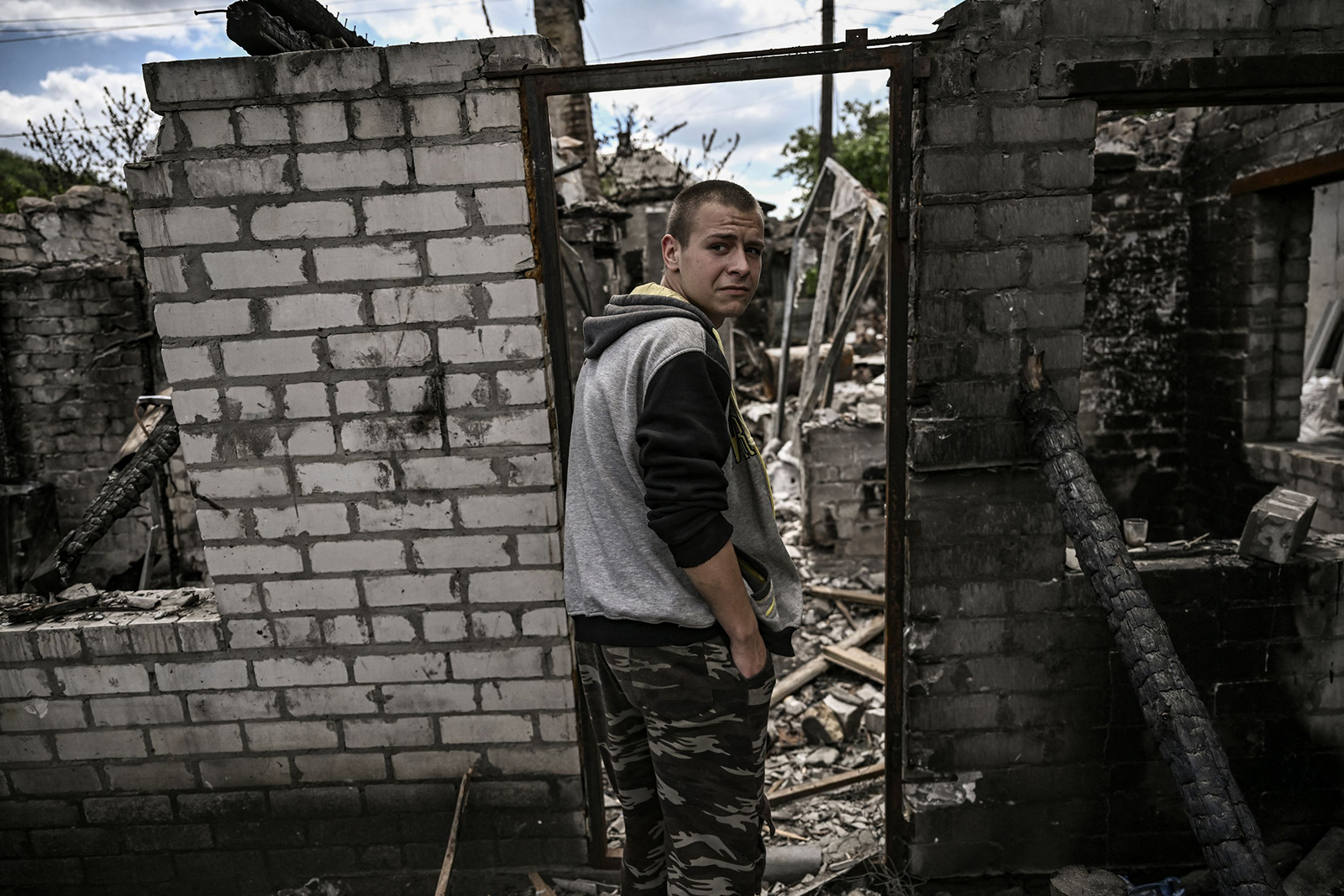 Ivan Sosnin, 19, stands in front of his destroyed house in the city of Lysychansk at the eastern Ukrainian region of Donbas on June 7.