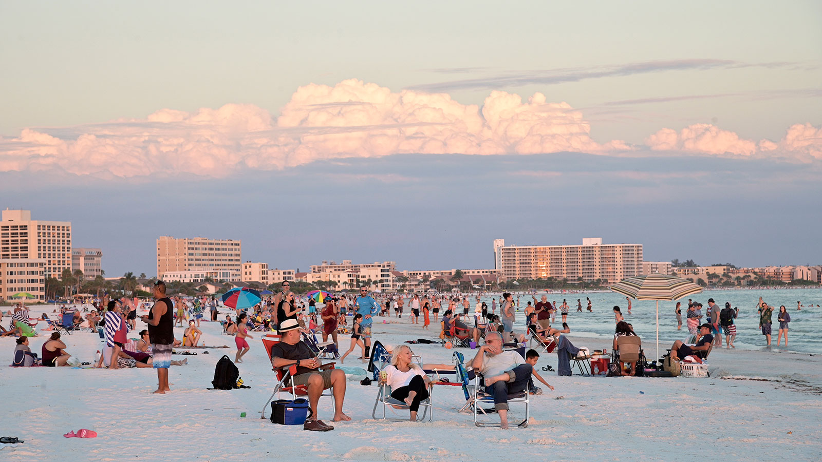 Visitors enjoy Siesta Key Beach as the sun sets over the Gulf of Mexico in Sarasota, Florida on June 17.