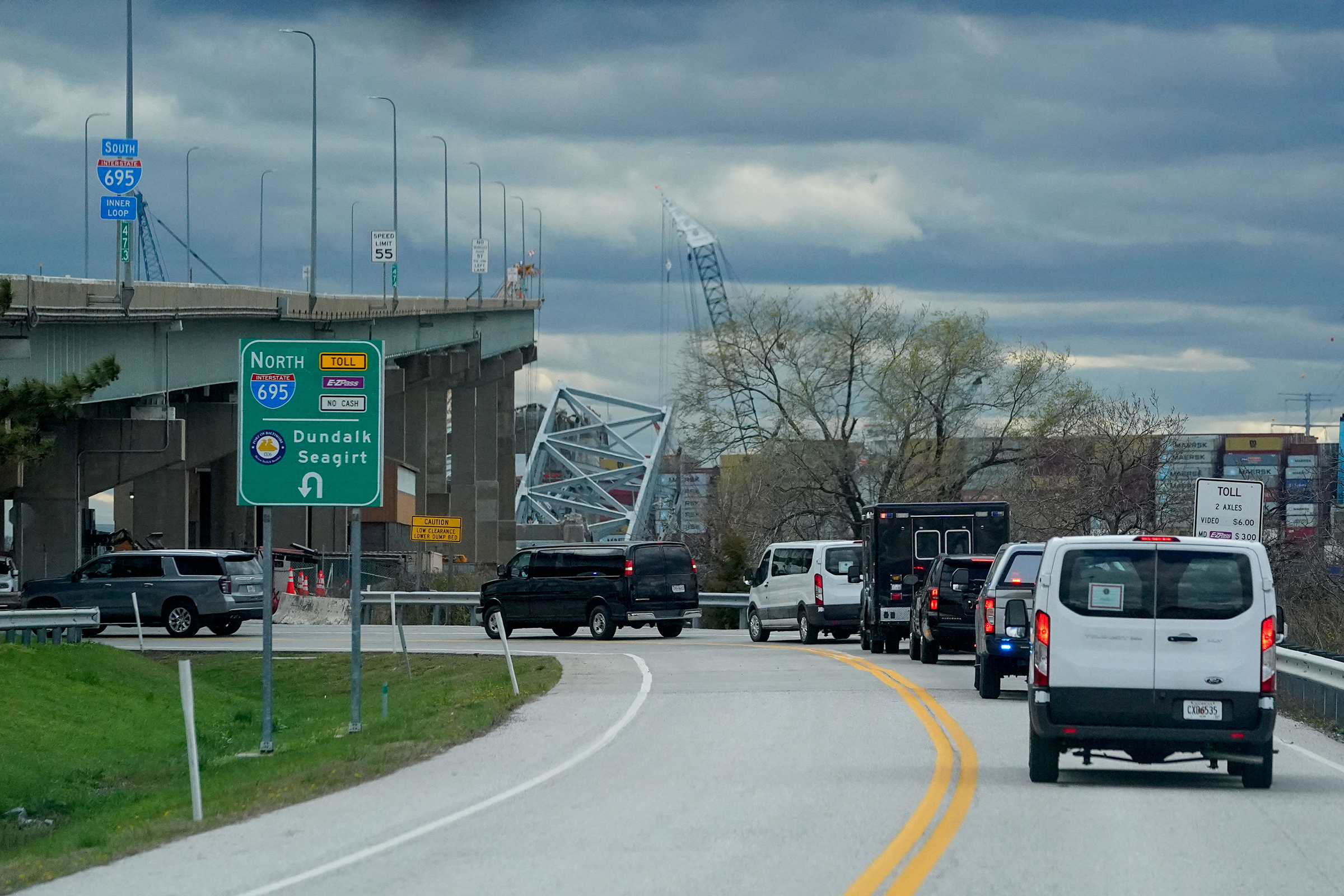 Vehicles that are part of the motorcade of President Joe Biden drive near the collapsed Francis Scott Key Bridge, in Dundalk, Maryland, on Friday.