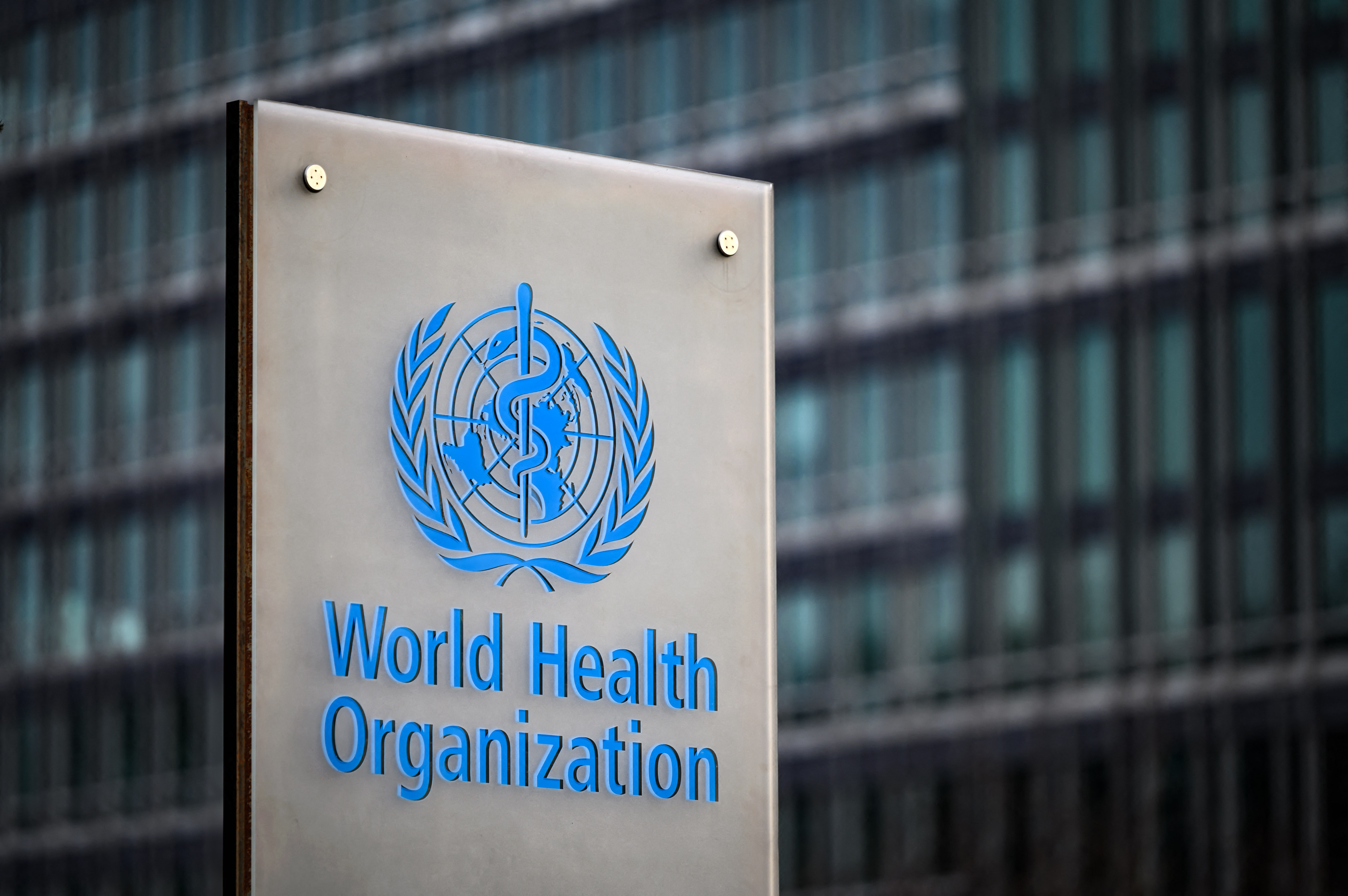 This photograph taken on December 7, 2021 shows a sign of the World Health Organisation (WHO) at their headquarters in Geneva. 