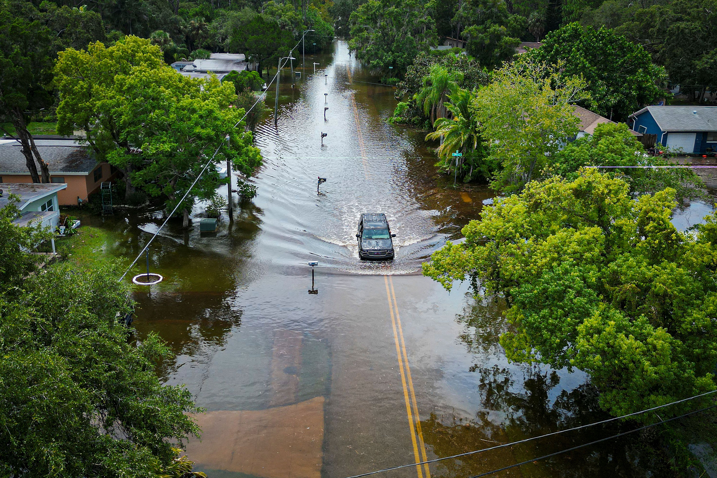 A vehicle drives down a flooded street in New Port Richey, Florida, on Wednesday. 