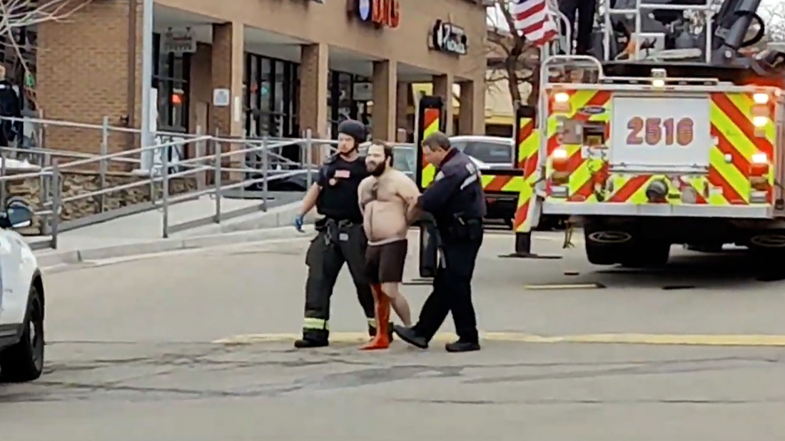 Ahmad Al Aliwi Alissa is led away in handcuffs from the scene of the shooting in Boulder, Colorado, on March 22.