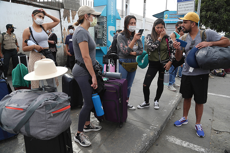 Tourists from the United States wait outside the closed Jorge Chavez International Airport,i n Callao Peru, for a member of the U.S. Embassy to escort them to a flight that will fly them back to the U.S. on Friday, March 20.