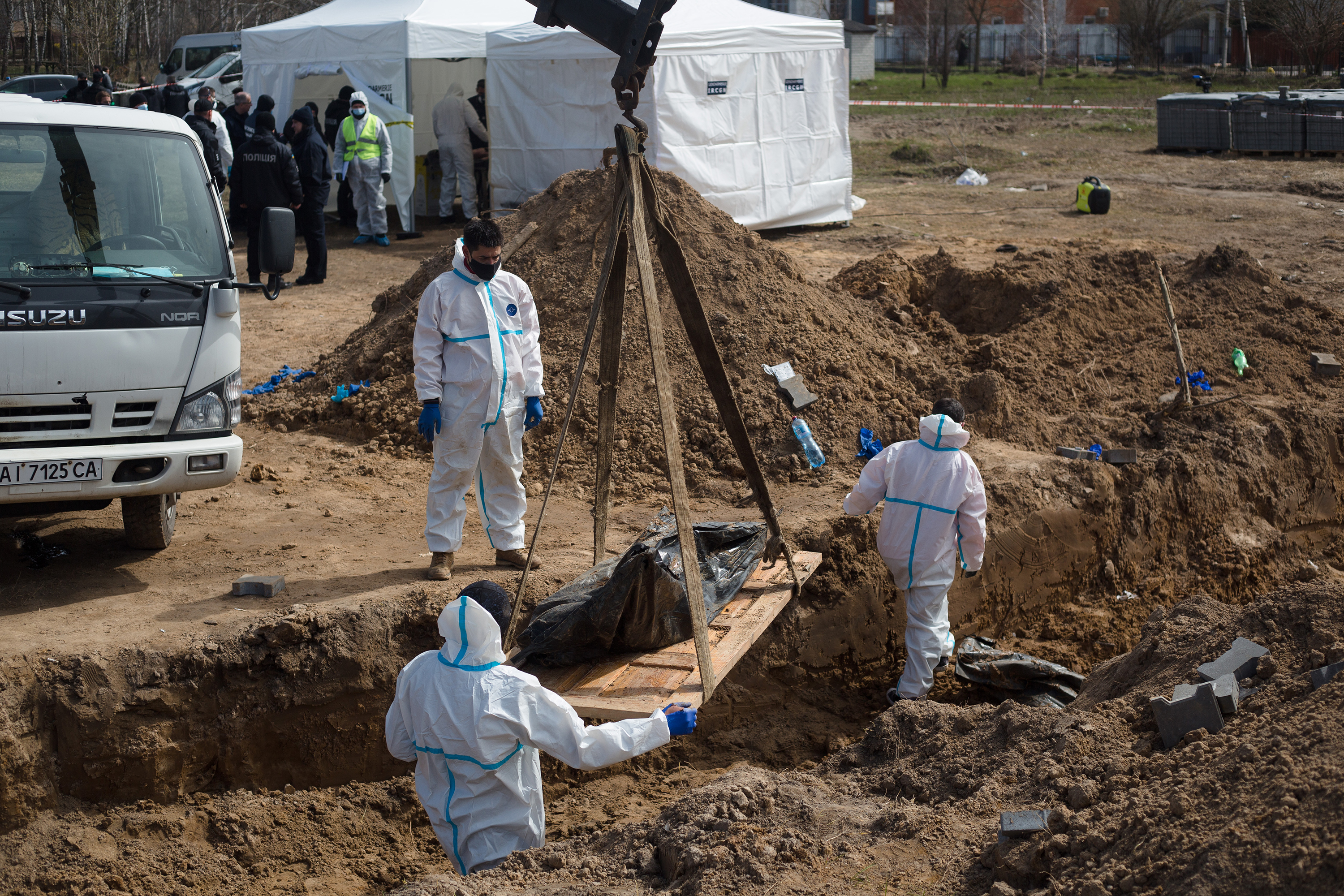 Workers remove bodies from a mass grave in Bucha, Ukraine on April 14.