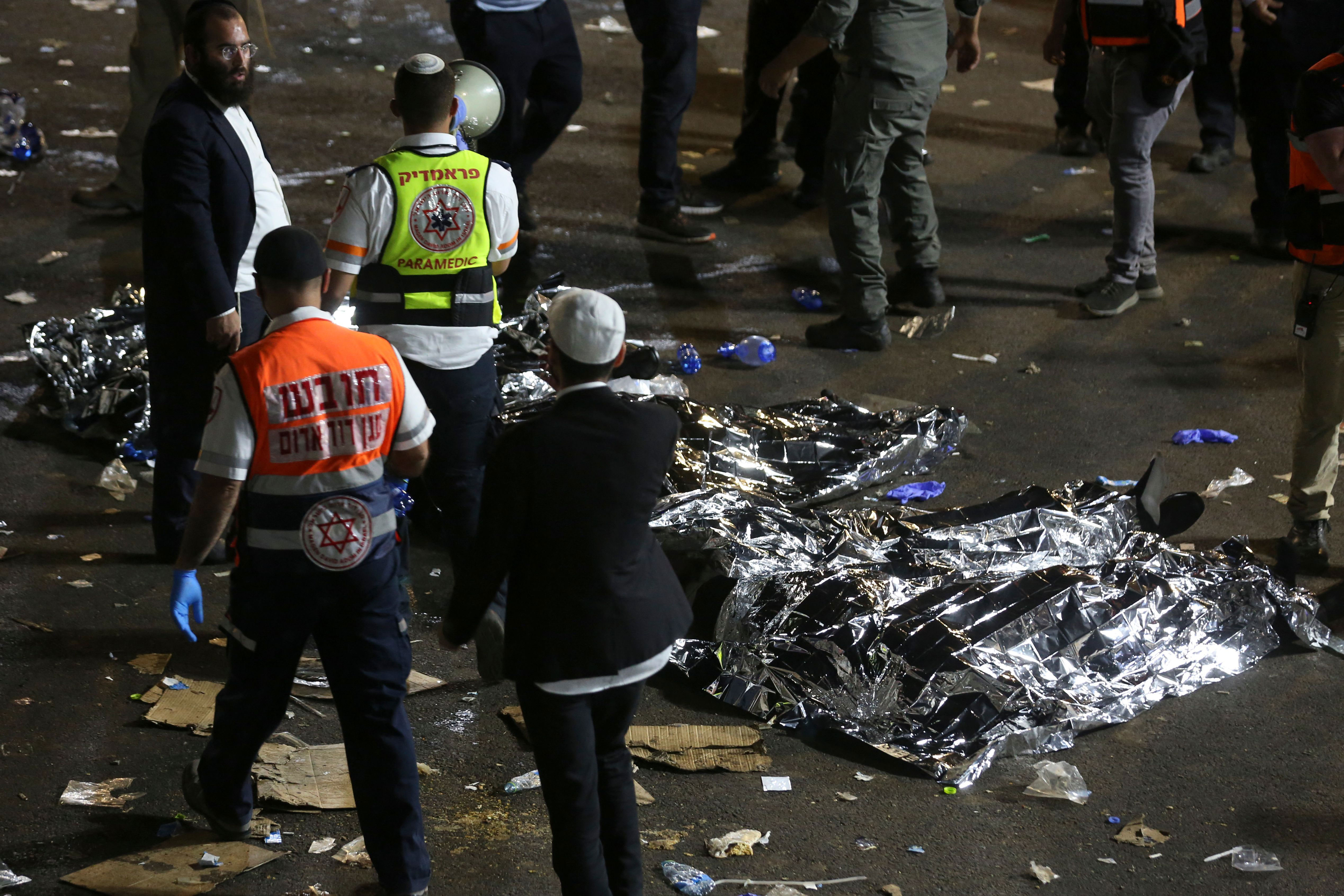 Dozens were killed during a crush at the event; in this photo, paramedics and worshipers stand next to covered bodies in the wake of the disaster.  