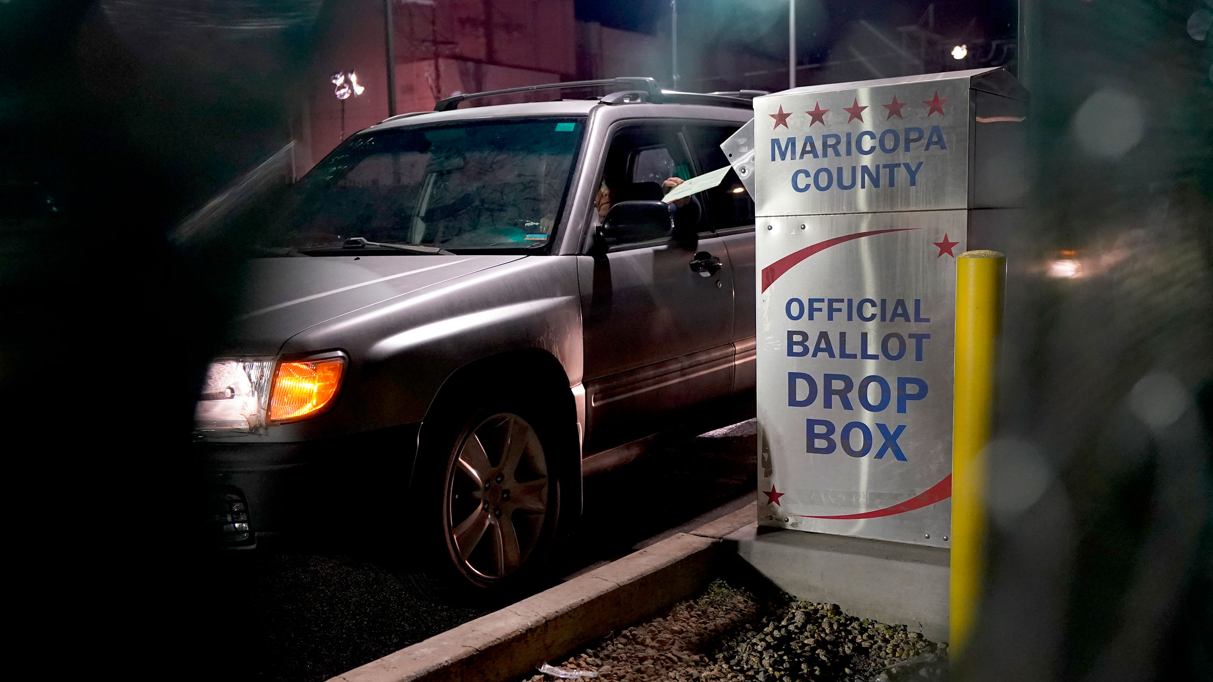 A voter drops off a ballot Tuesday outside the Maricopa County Recorders Office in Phoenix.