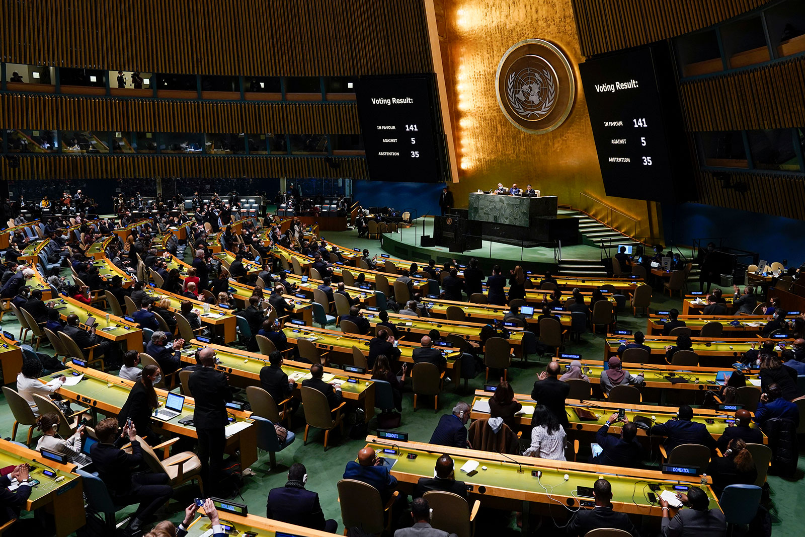 Voting results are displayed on screens at the United Nations General Assembly on March 2.