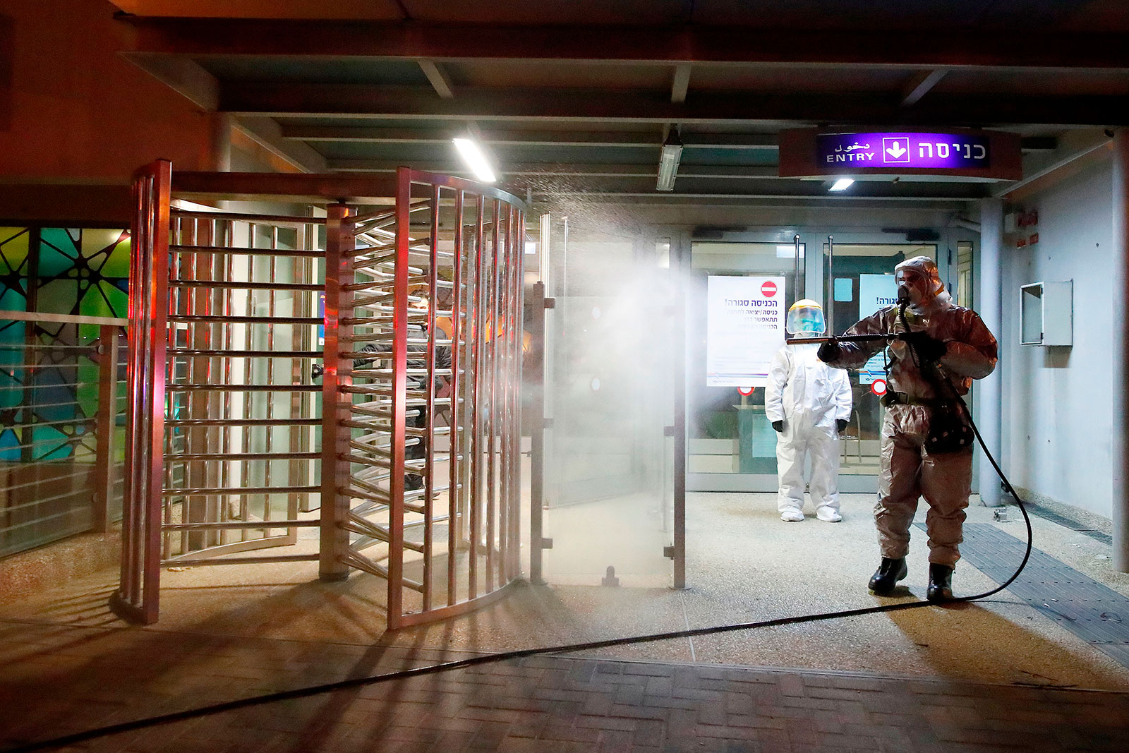 A firefighter sprays a turnstile with disinfectant at the Moshe Dayan Railway Station in Israel.